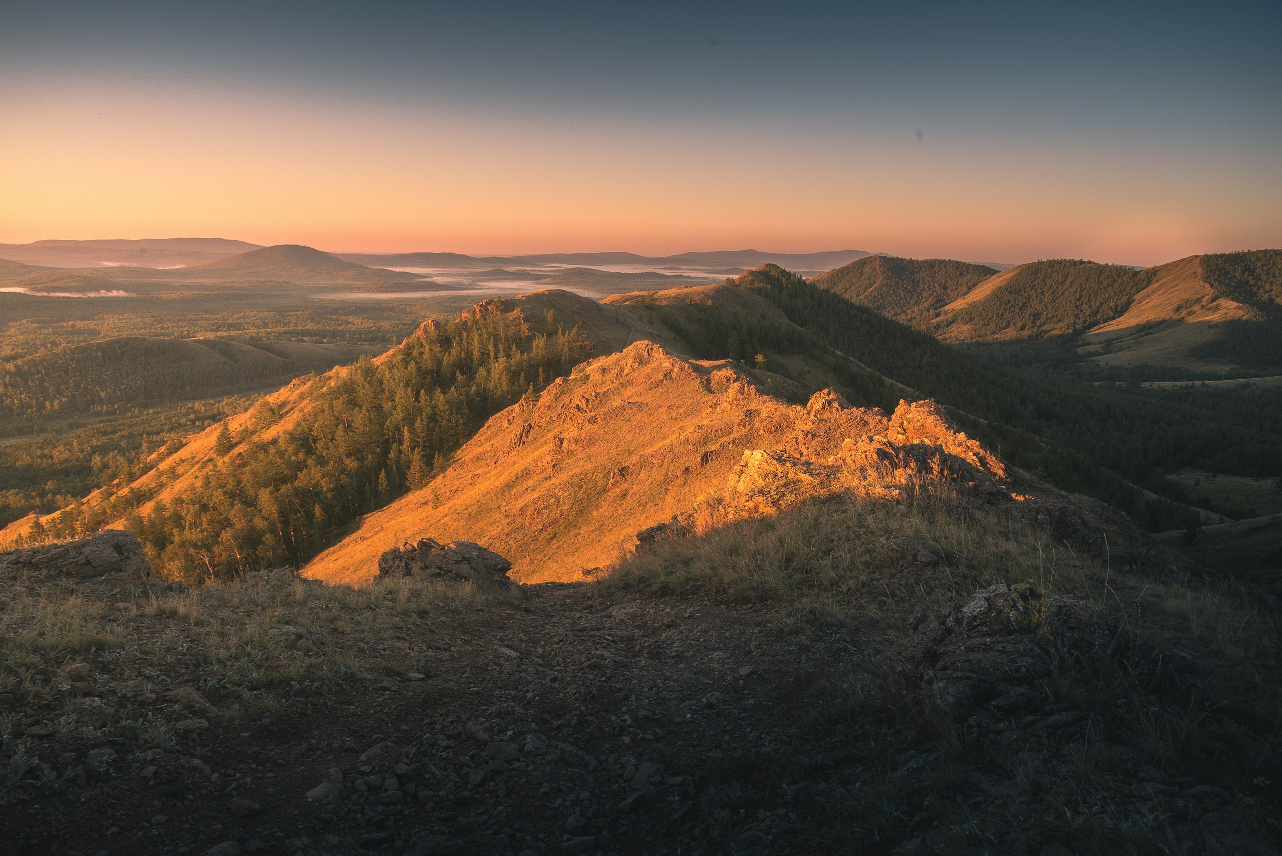Mountain peaks bathed in golden sunrise light HD Wallpaper