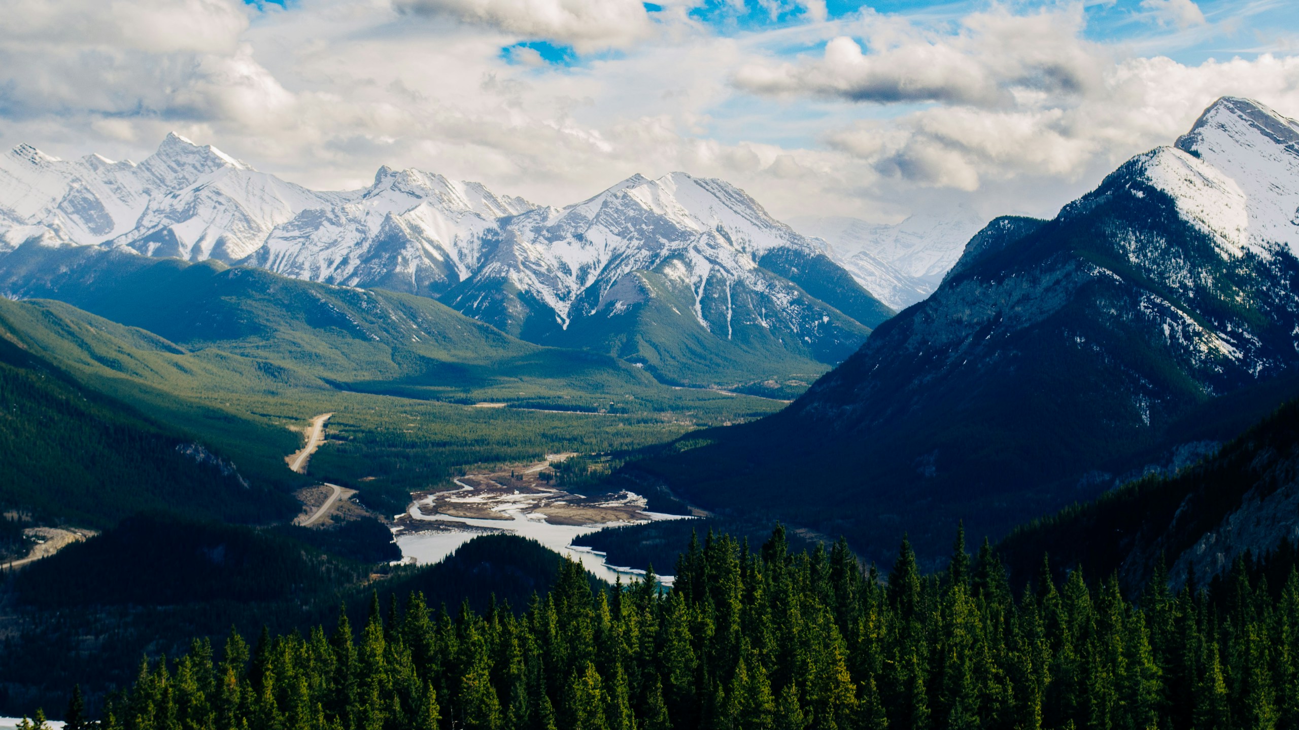 Snow-capped mountains and green valley with river HD Wallpaper