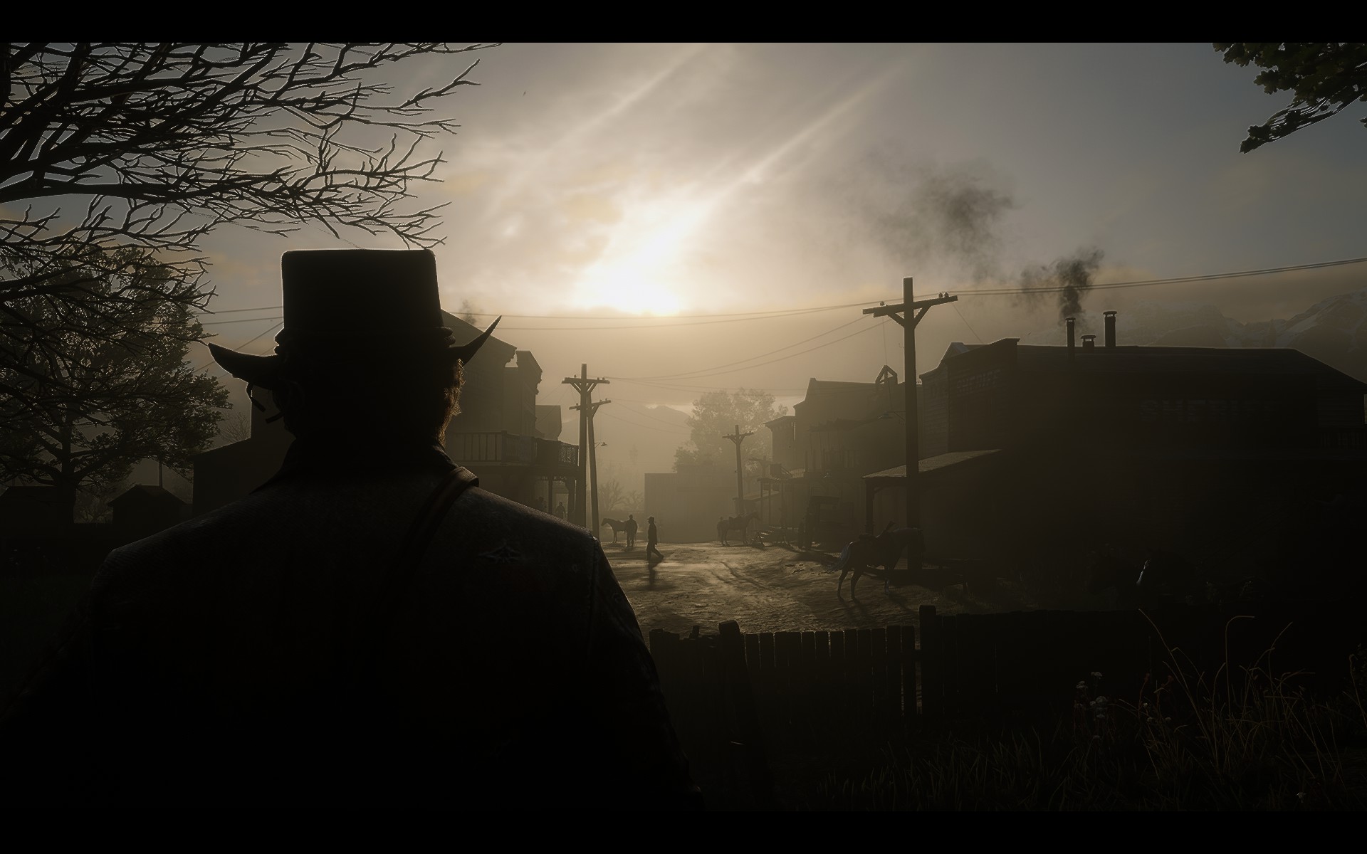 Man in hat looks over dusty town at sunrise HD Wallpaper