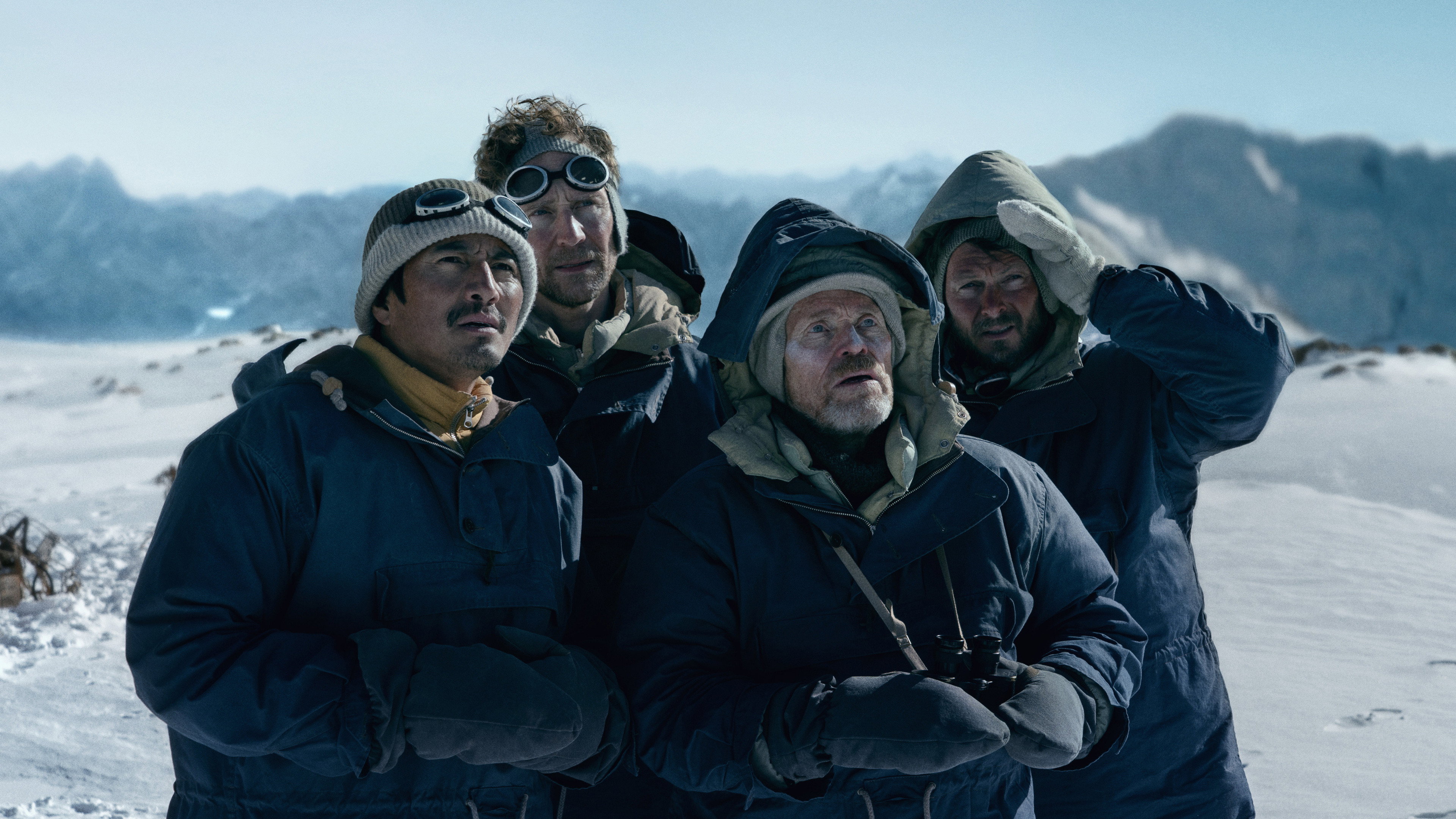 Four men in winter gear on a snowy mountain HD Wallpaper