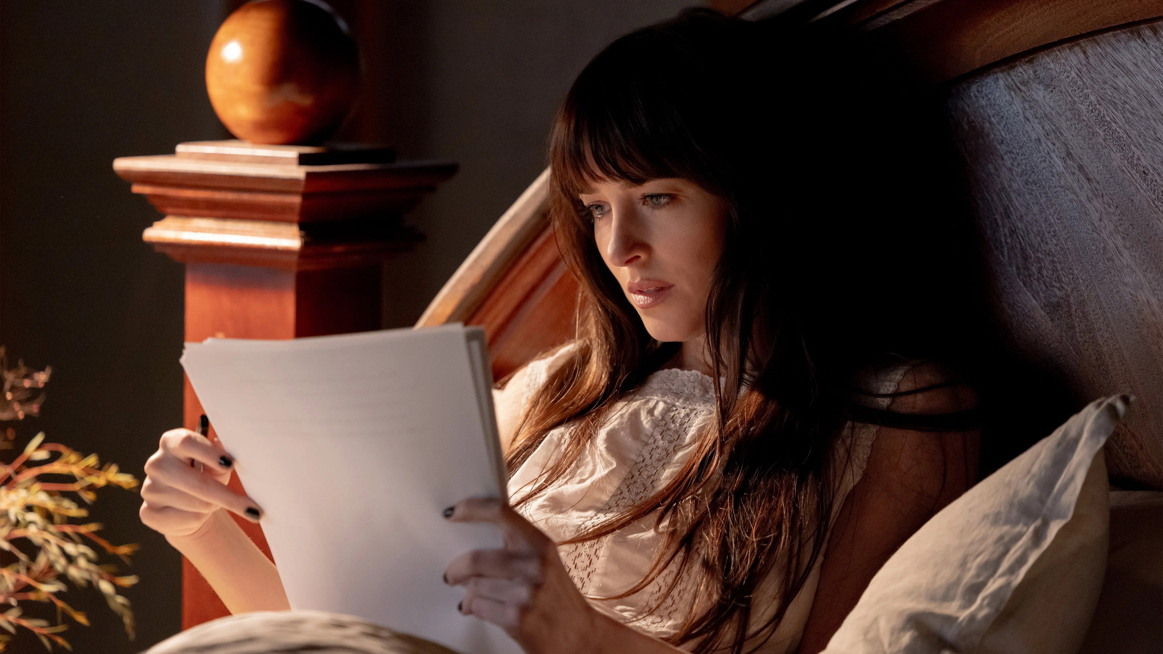 Dakota Johnson reading in bed HD Wallpaper