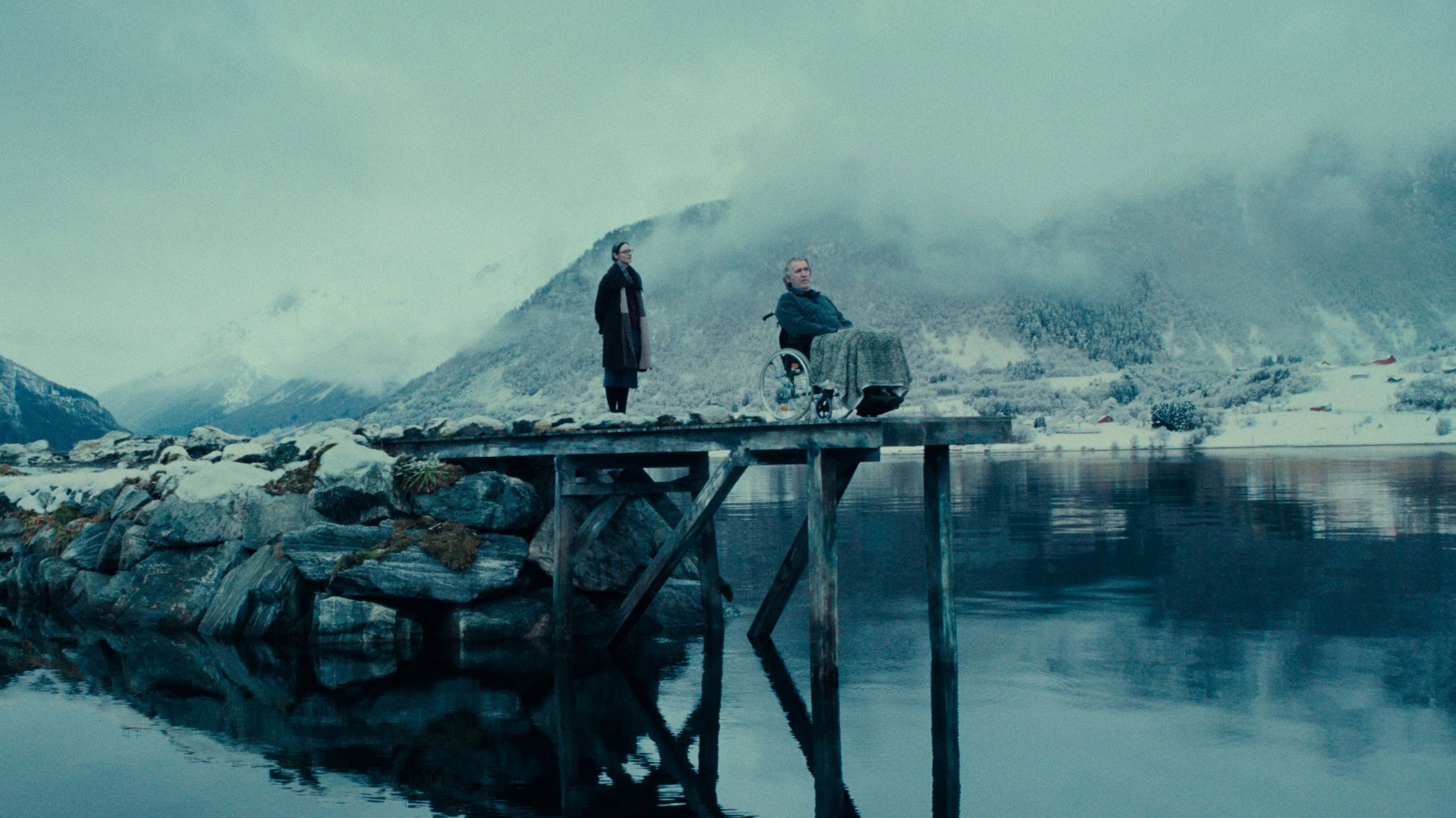 Two people on a pier in a snowy landscape HD Wallpaper