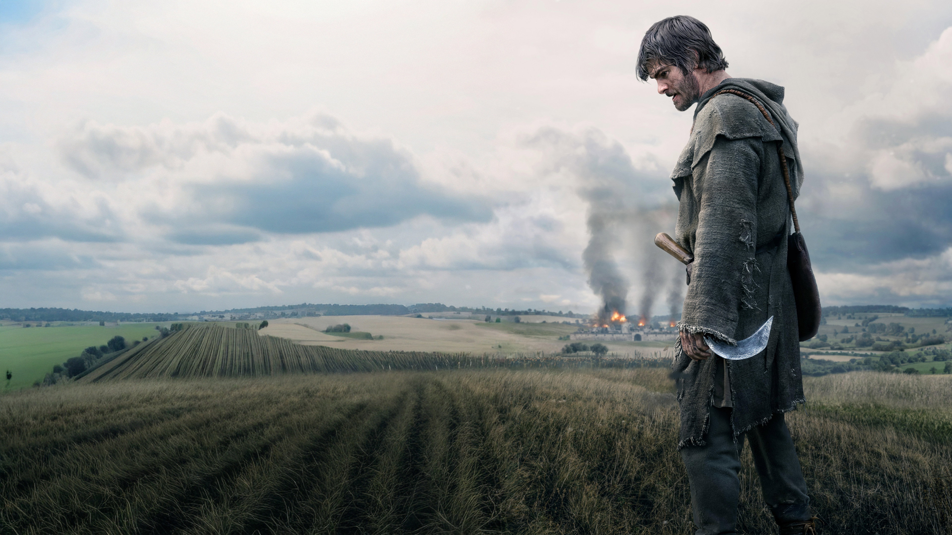 Man with scythe looks at burning village HD Wallpaper