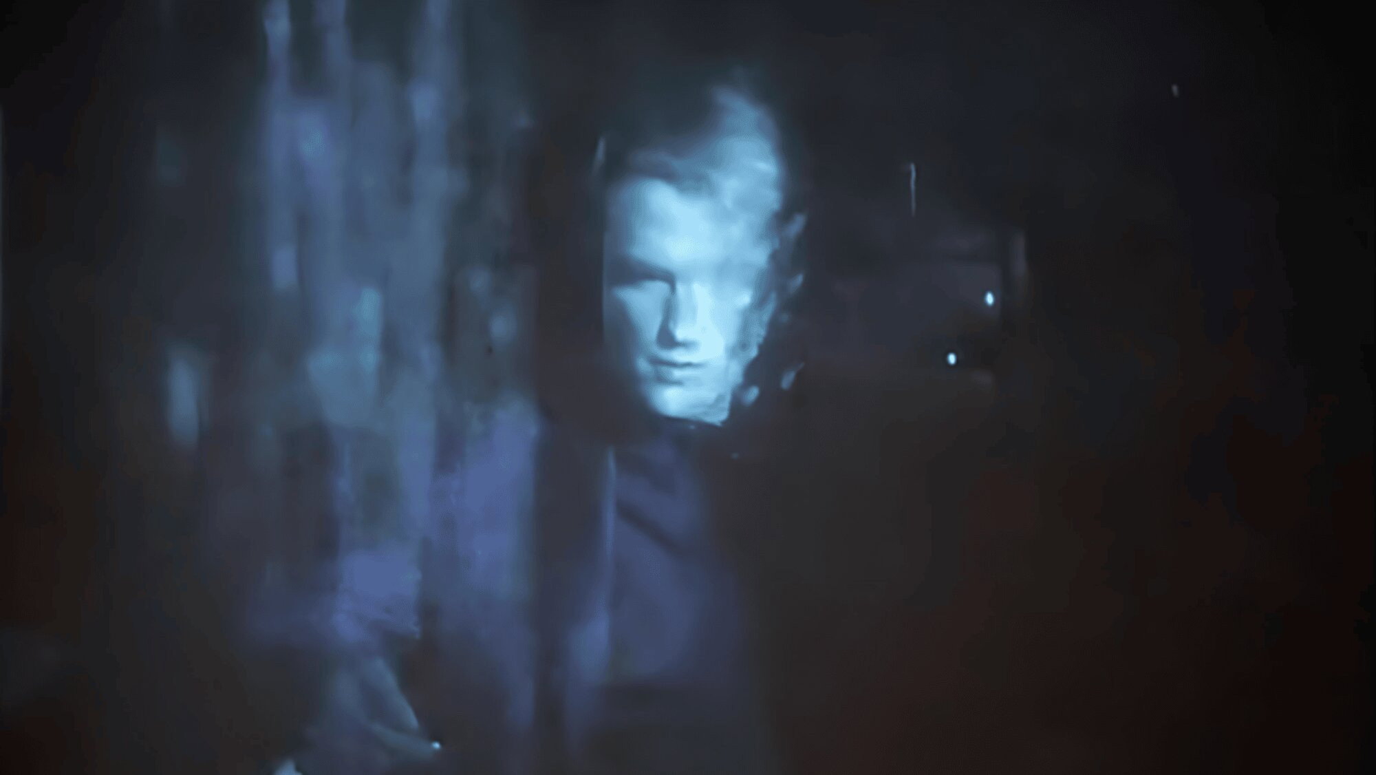A man's face projected in a dark, blurry environment HD Wallpaper