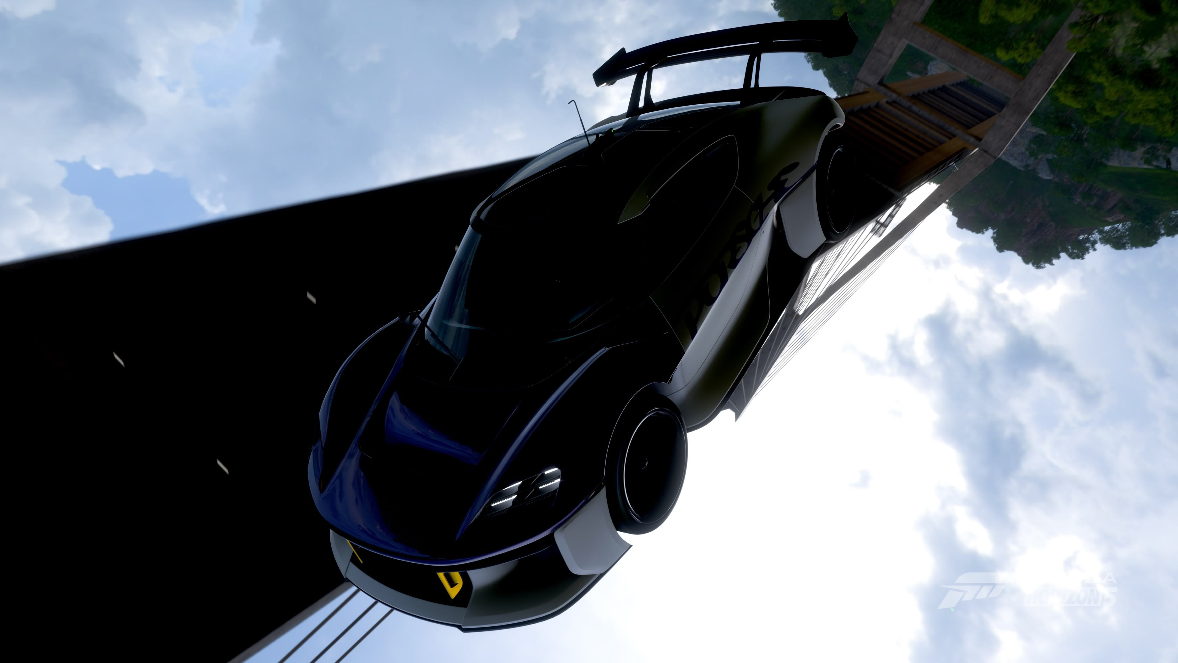 Dark sports car on a bridge with a forest background HD Wallpaper