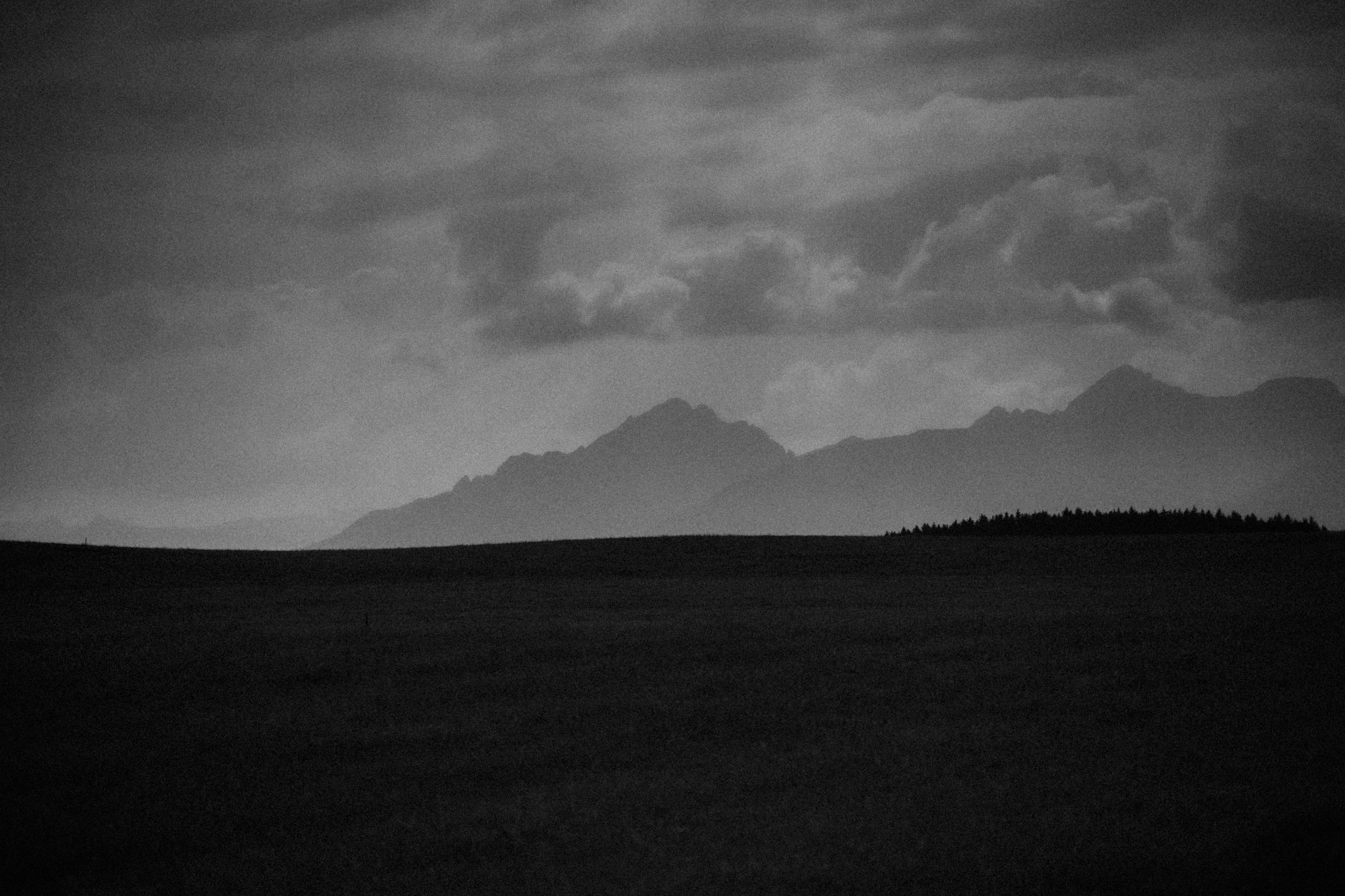 Dark, moody mountain landscape with stormy clouds HD Wallpaper