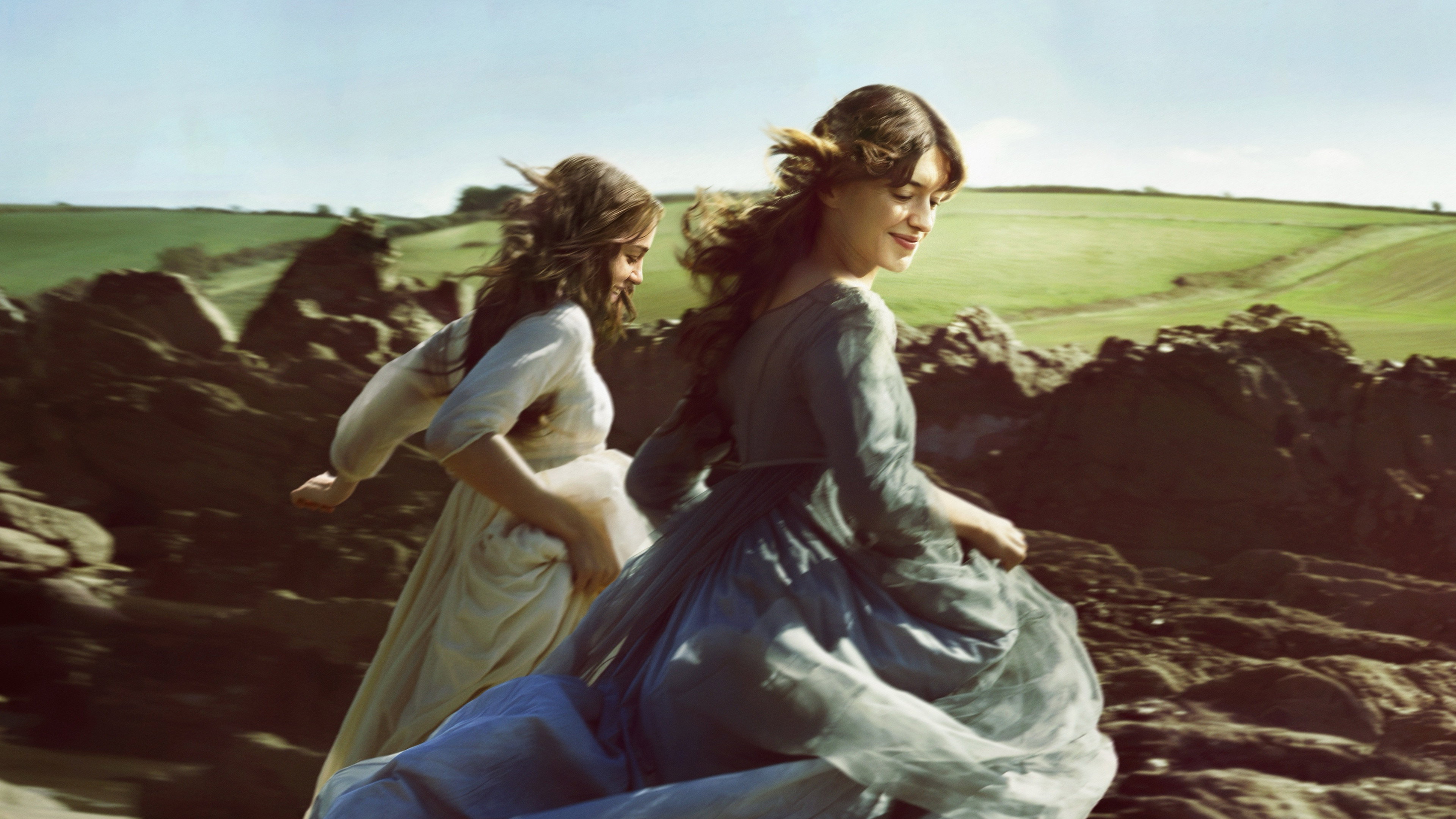 Two women running through a rocky landscape HD Wallpaper
