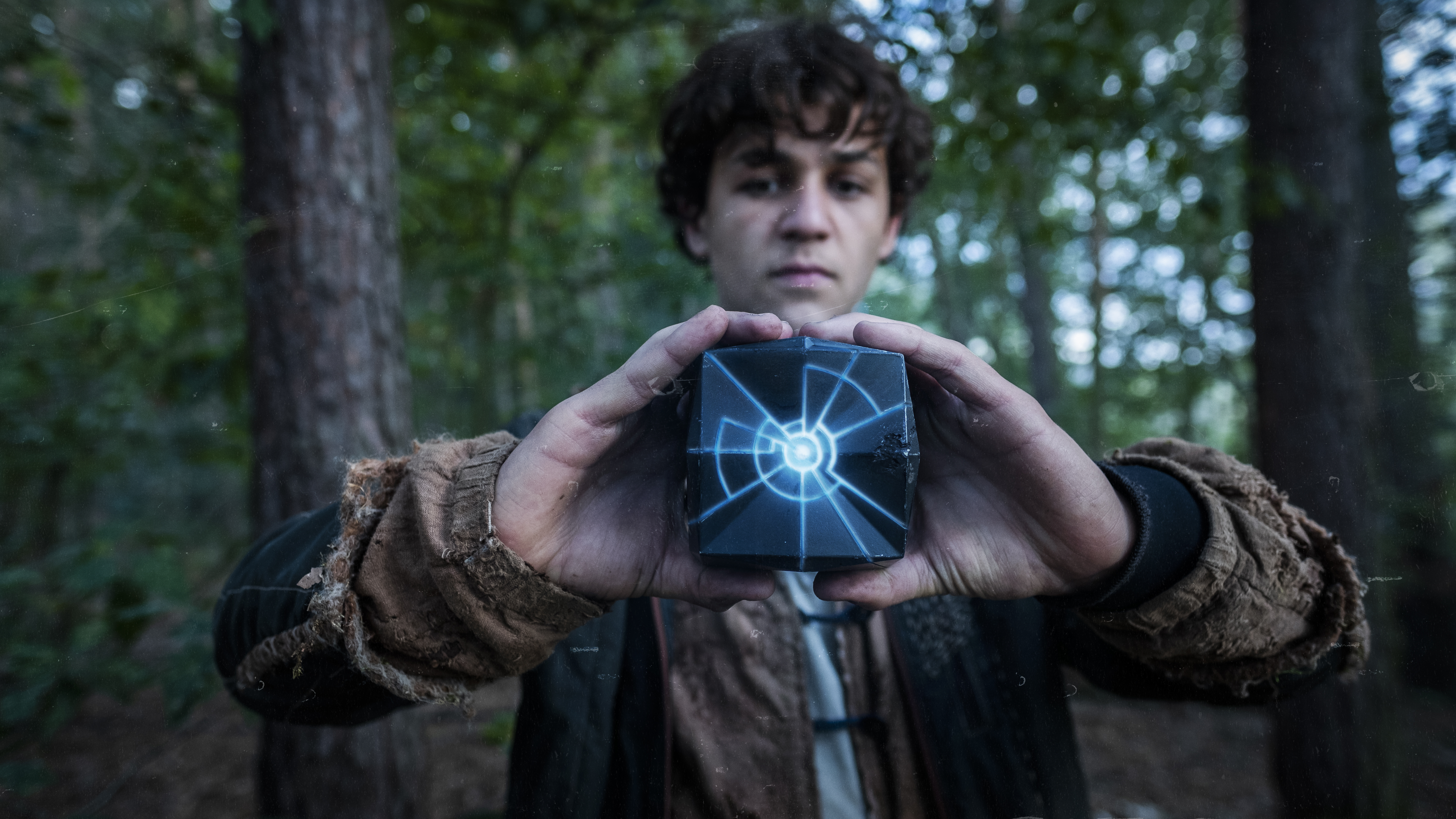 Young man holding a glowing cube in Tribes Of Europa 4K HD Wallpaper