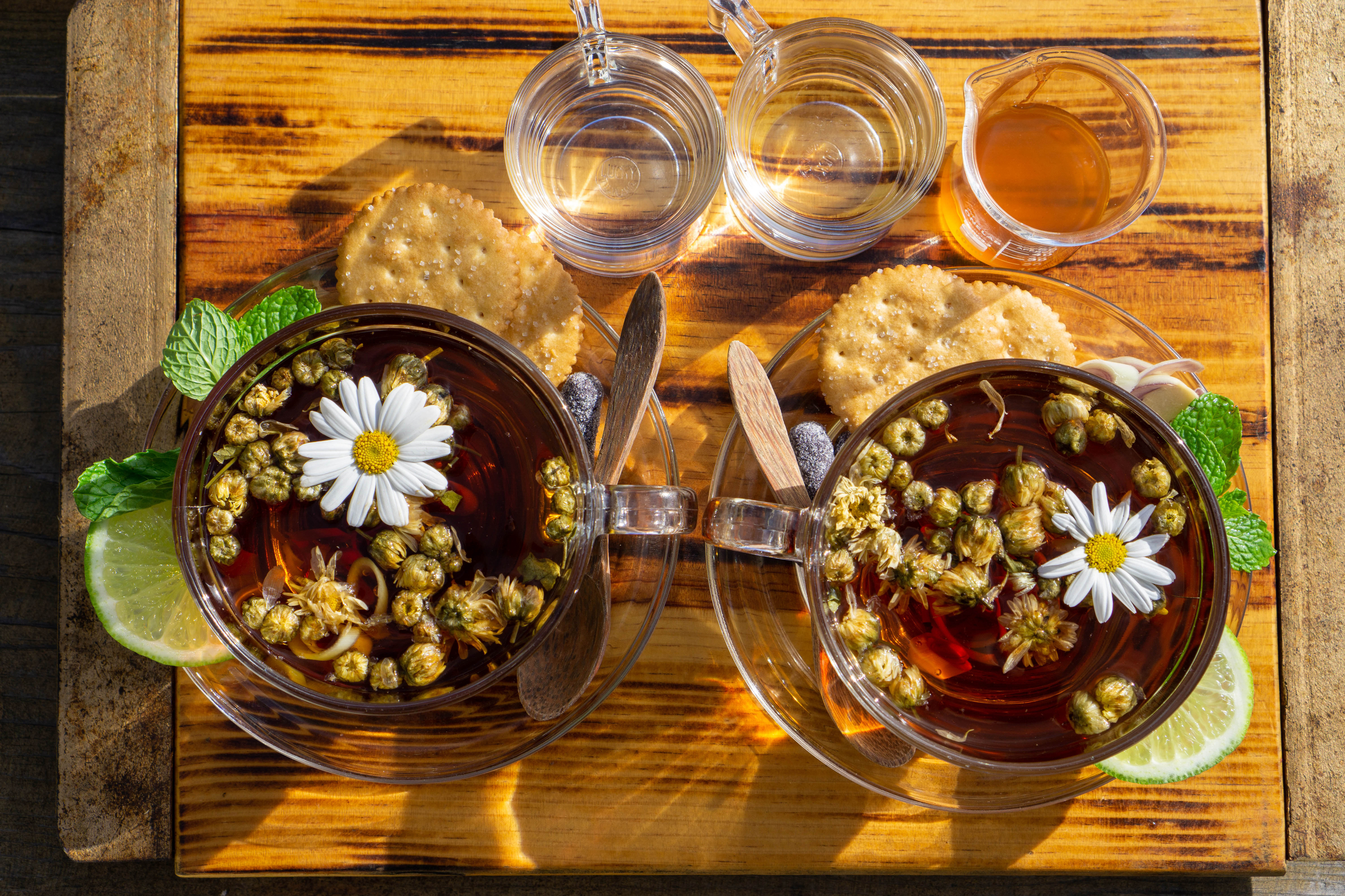 Two cups of chrysanthemum tea with honey and crackers HD Wallpaper