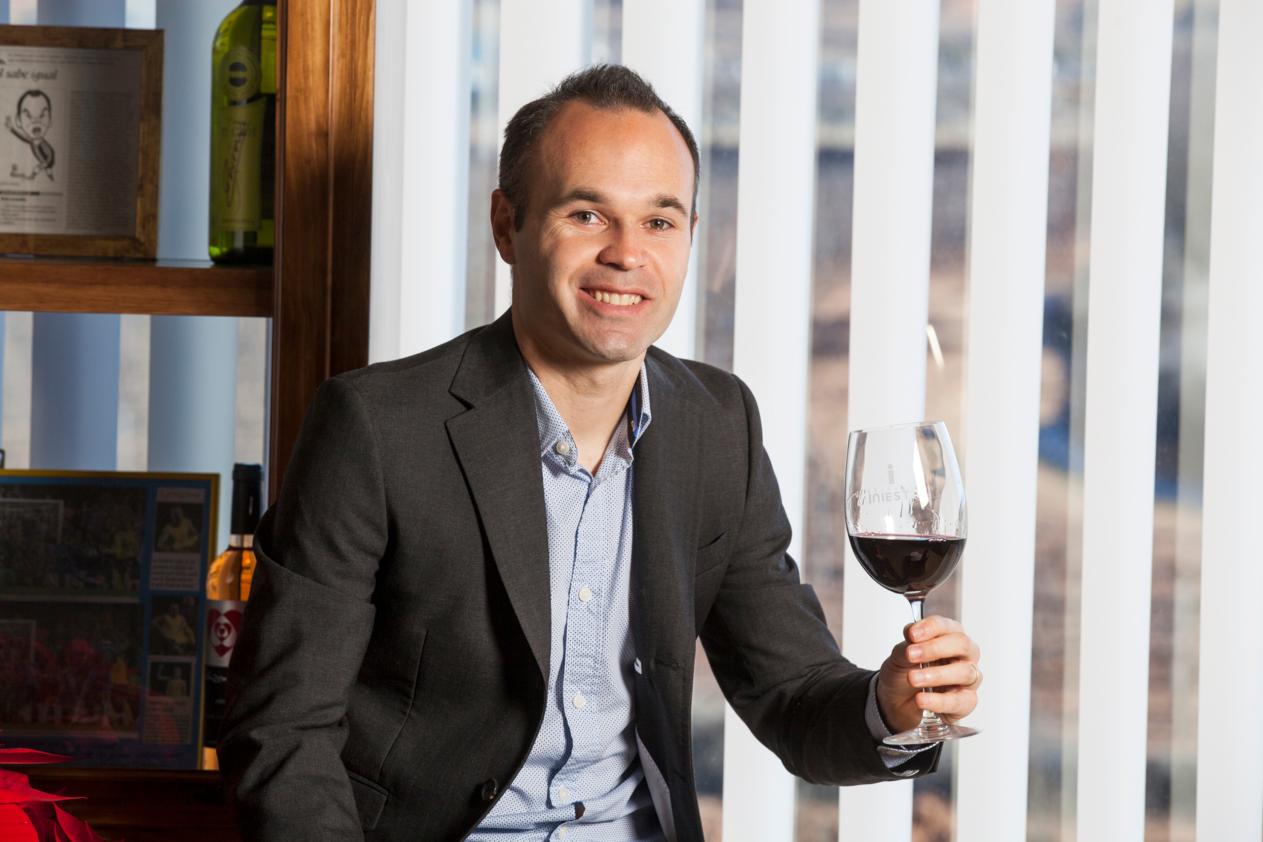 Andrés Iniesta holding a glass of red wine HD Wallpaper