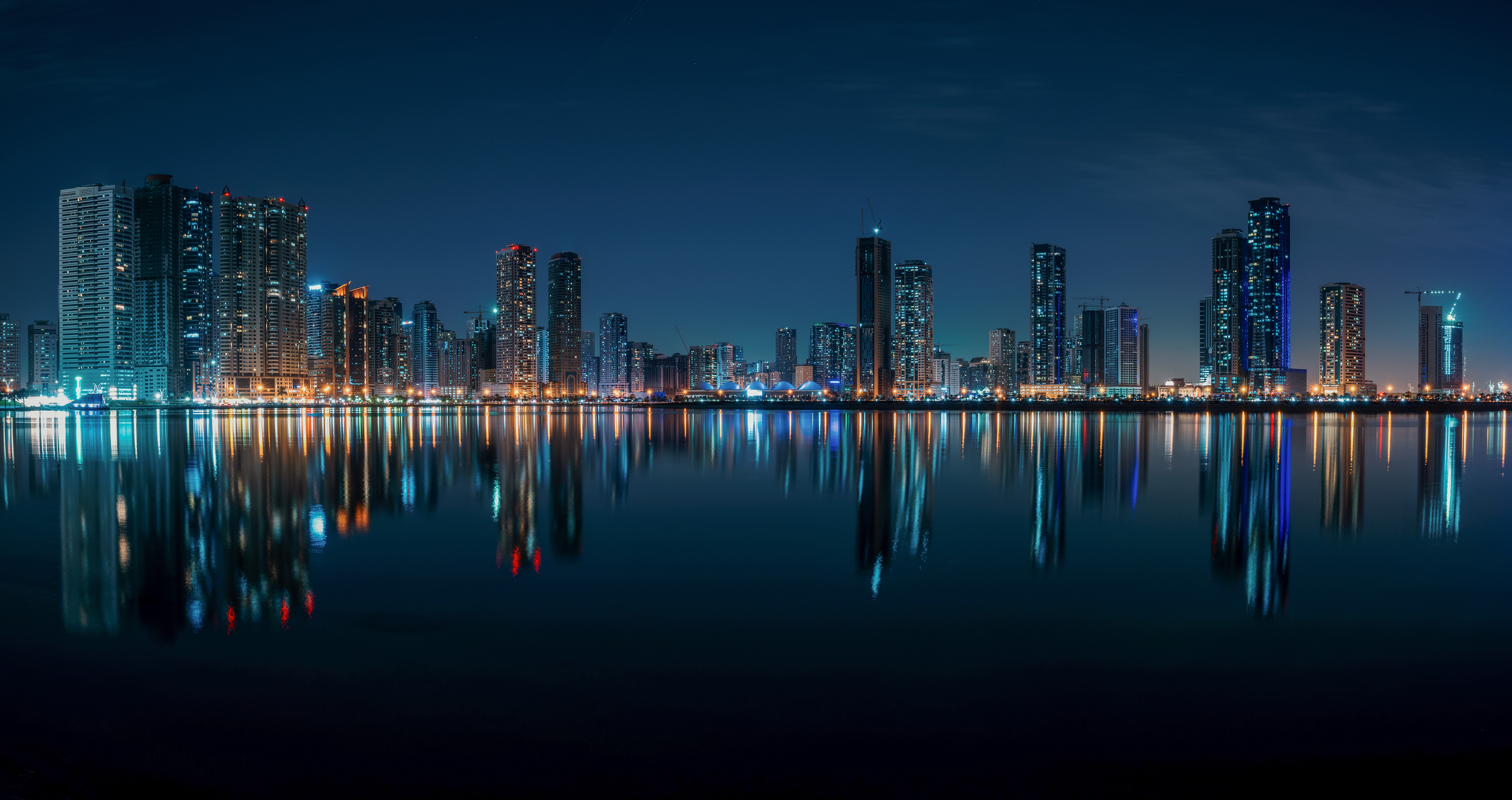 Sharjah skyline at night with reflections HD Wallpaper