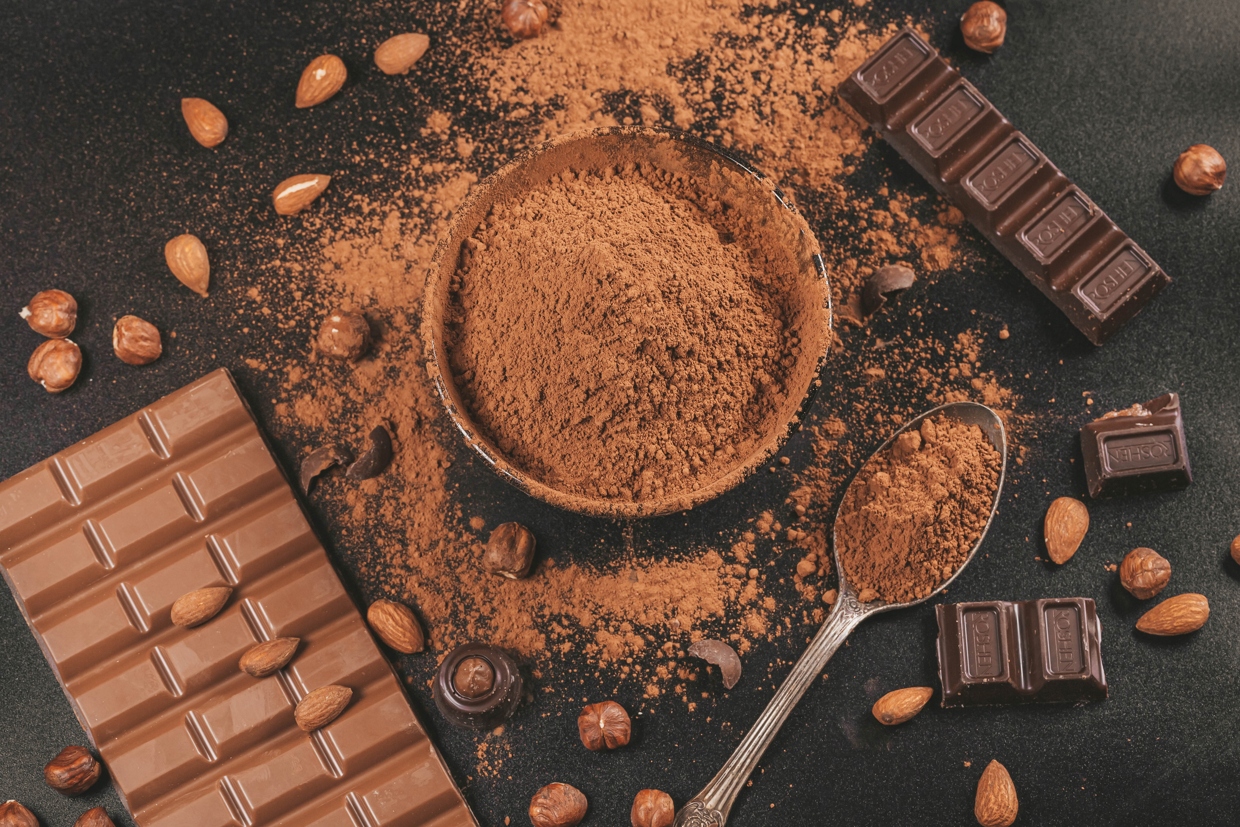Chocolate bars, cocoa powder, almonds, and hazelnuts still life HD Wallpaper