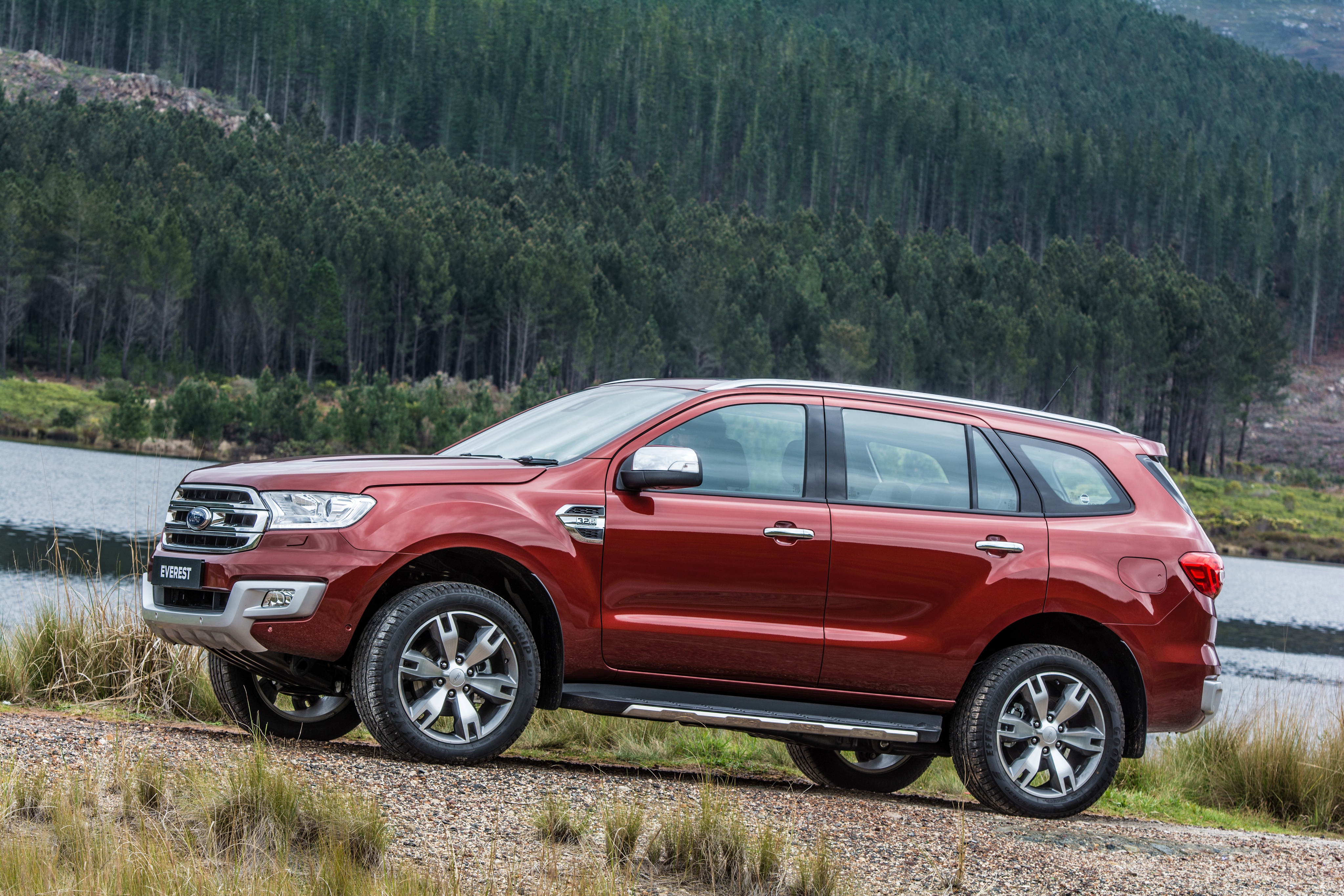 Red Ford Everest SUV parked by a lake with forest background HD Wallpaper
