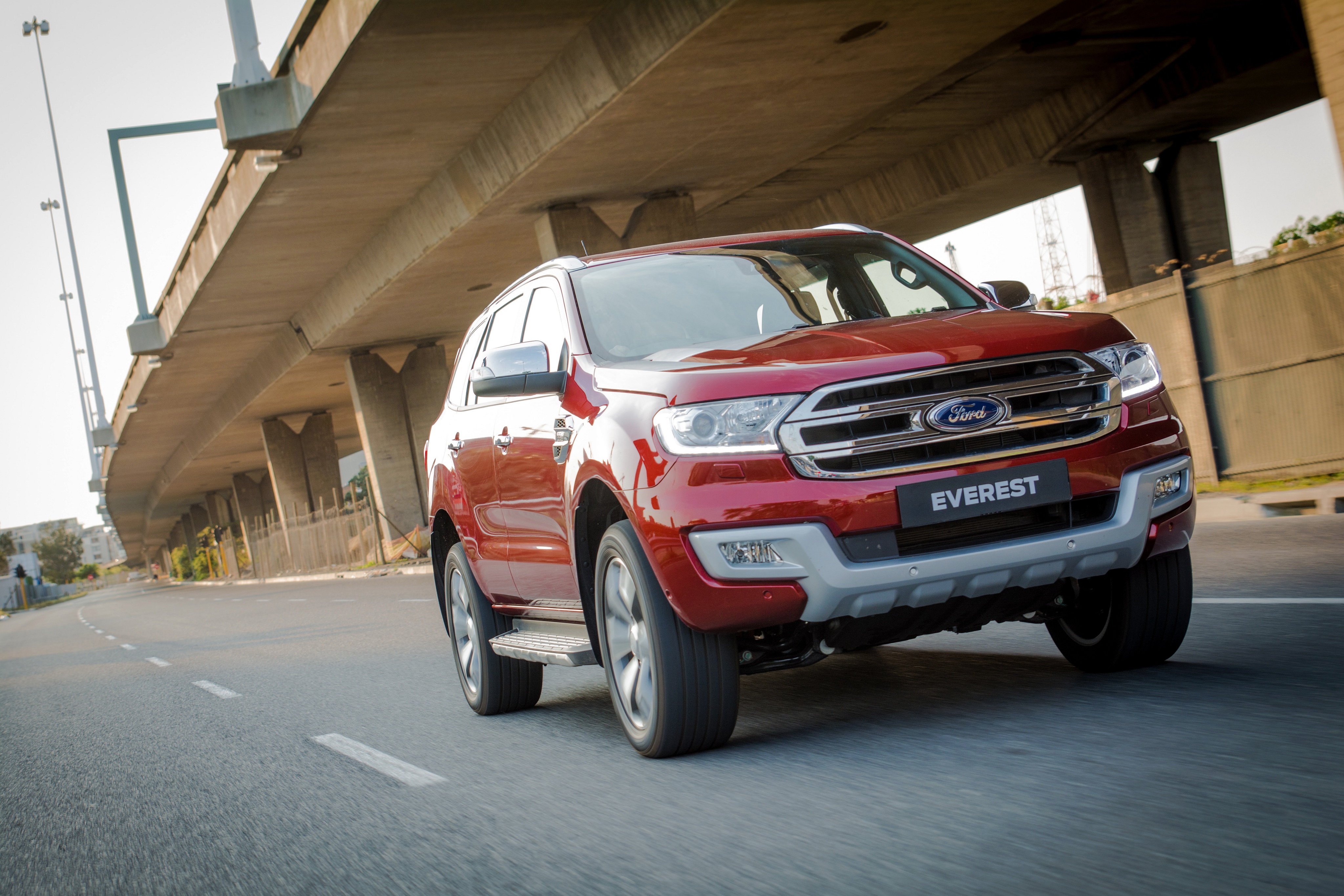 Red Ford Everest SUV driving under a bridge HD Wallpaper