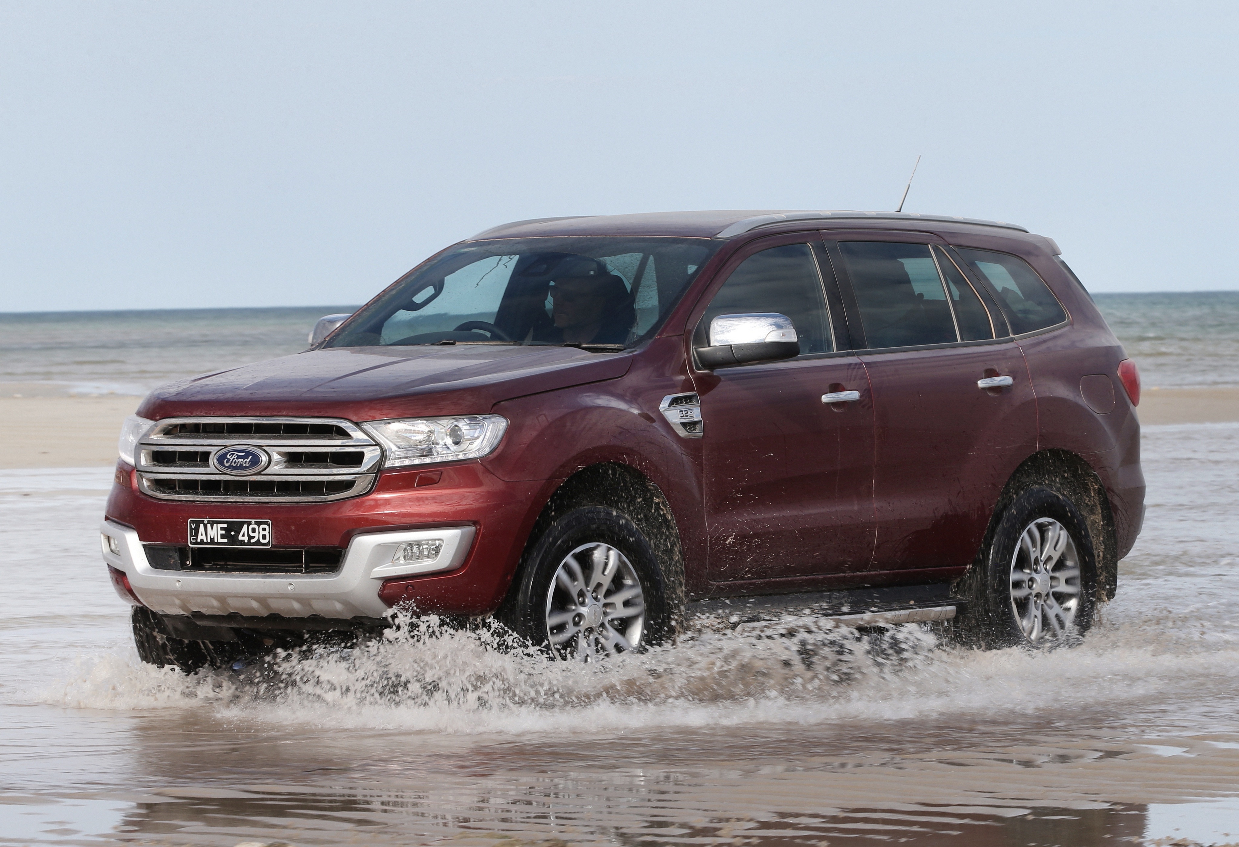 Red Ford Everest SUV driving through water on a beach HD Wallpaper