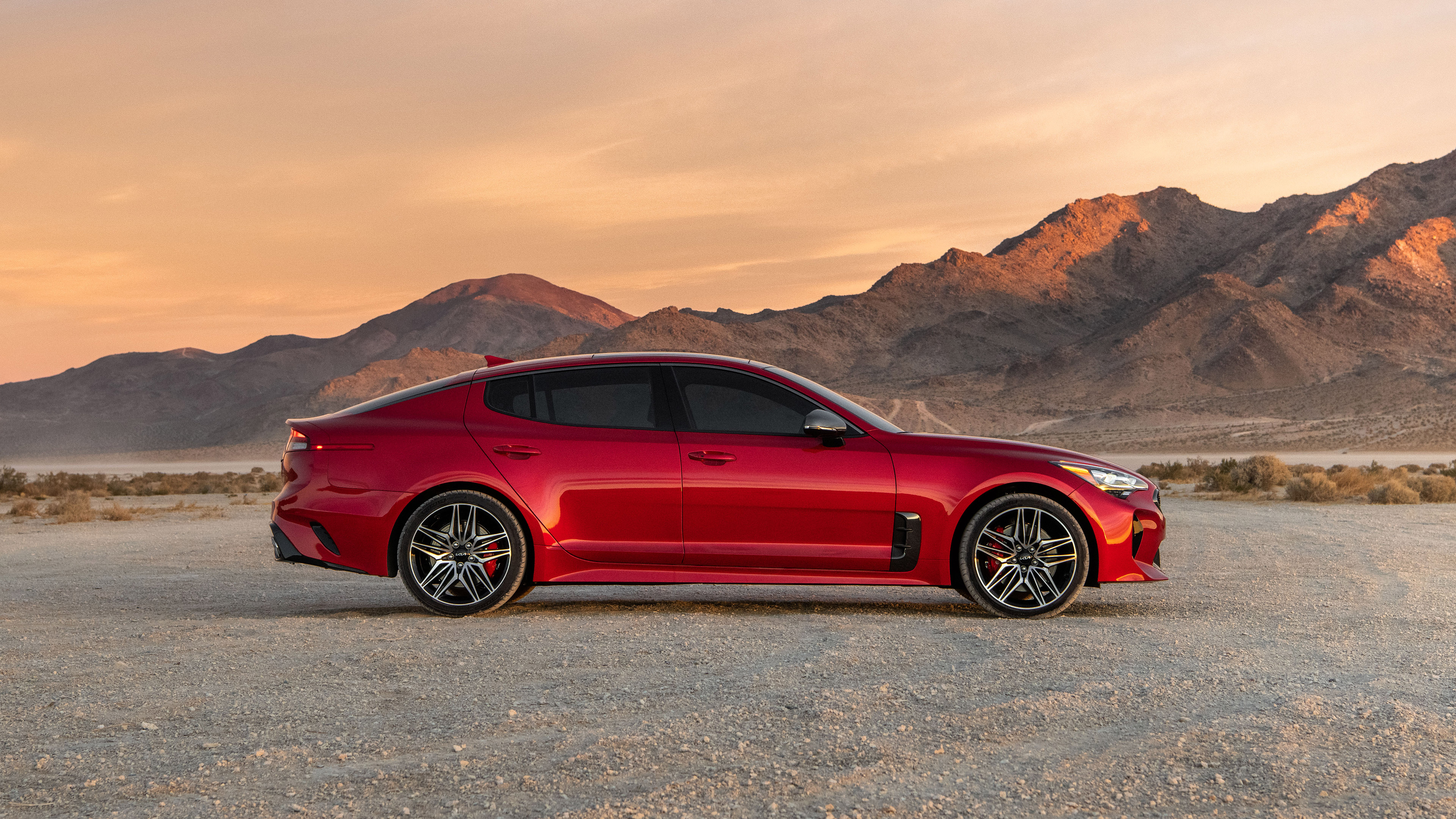 Red Kia Stinger in a Desert Landscape HD Wallpaper