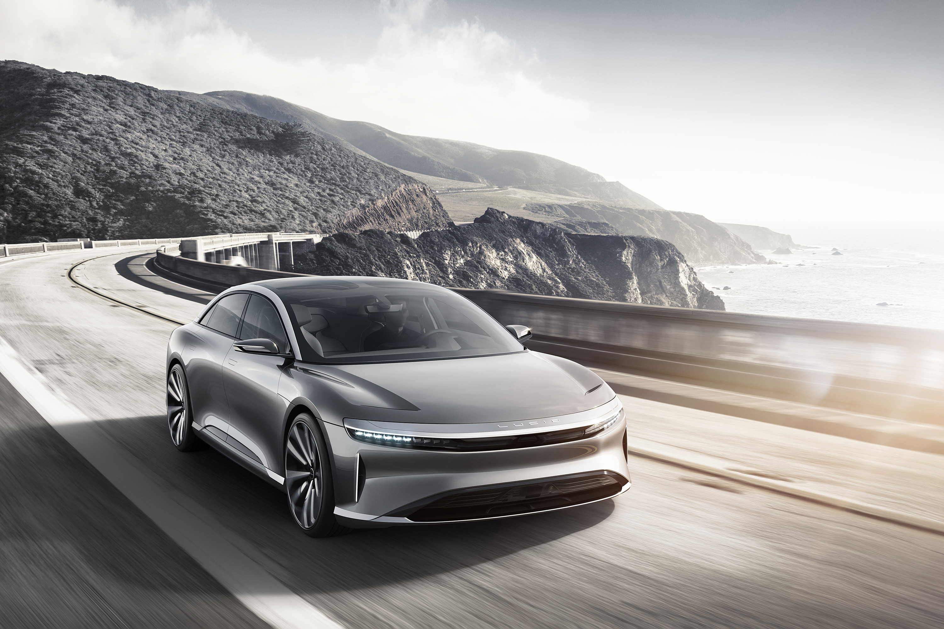 Silver Lucid Air Concept car driving on coastal highway HD Wallpaper