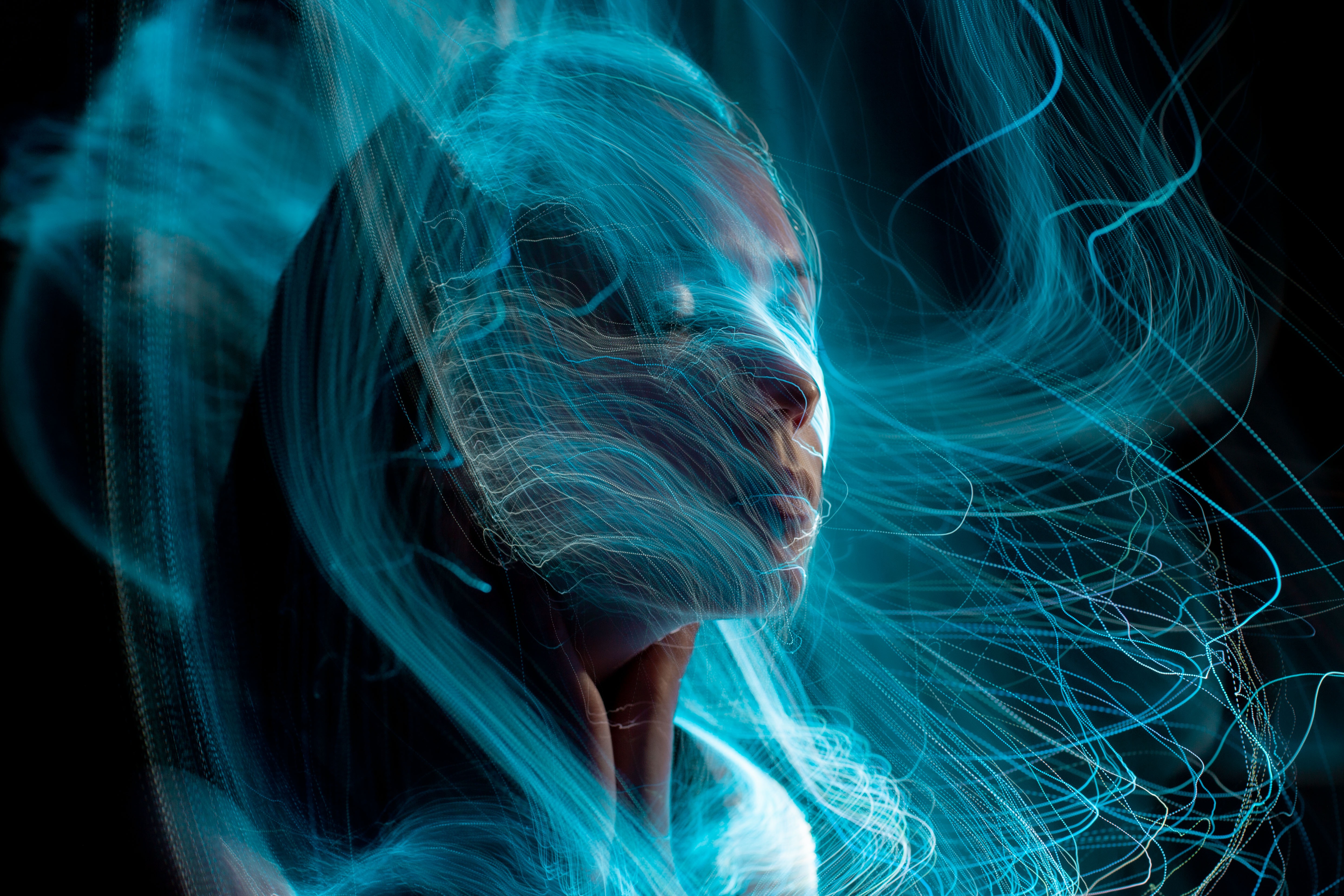 Woman's face enveloped in blue light trails HD Wallpaper