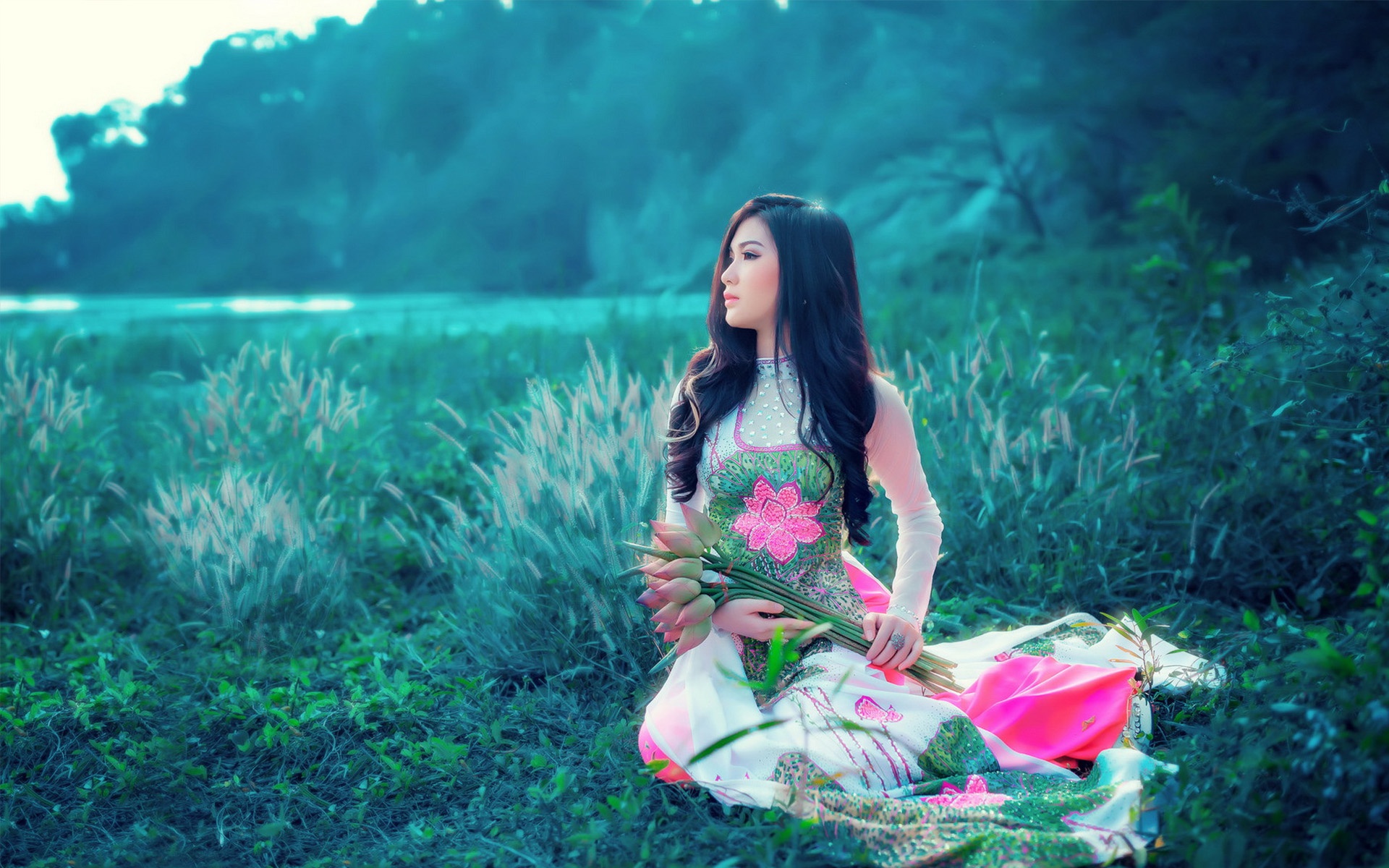 Woman in traditional dress holding lotus flowers HD Wallpaper