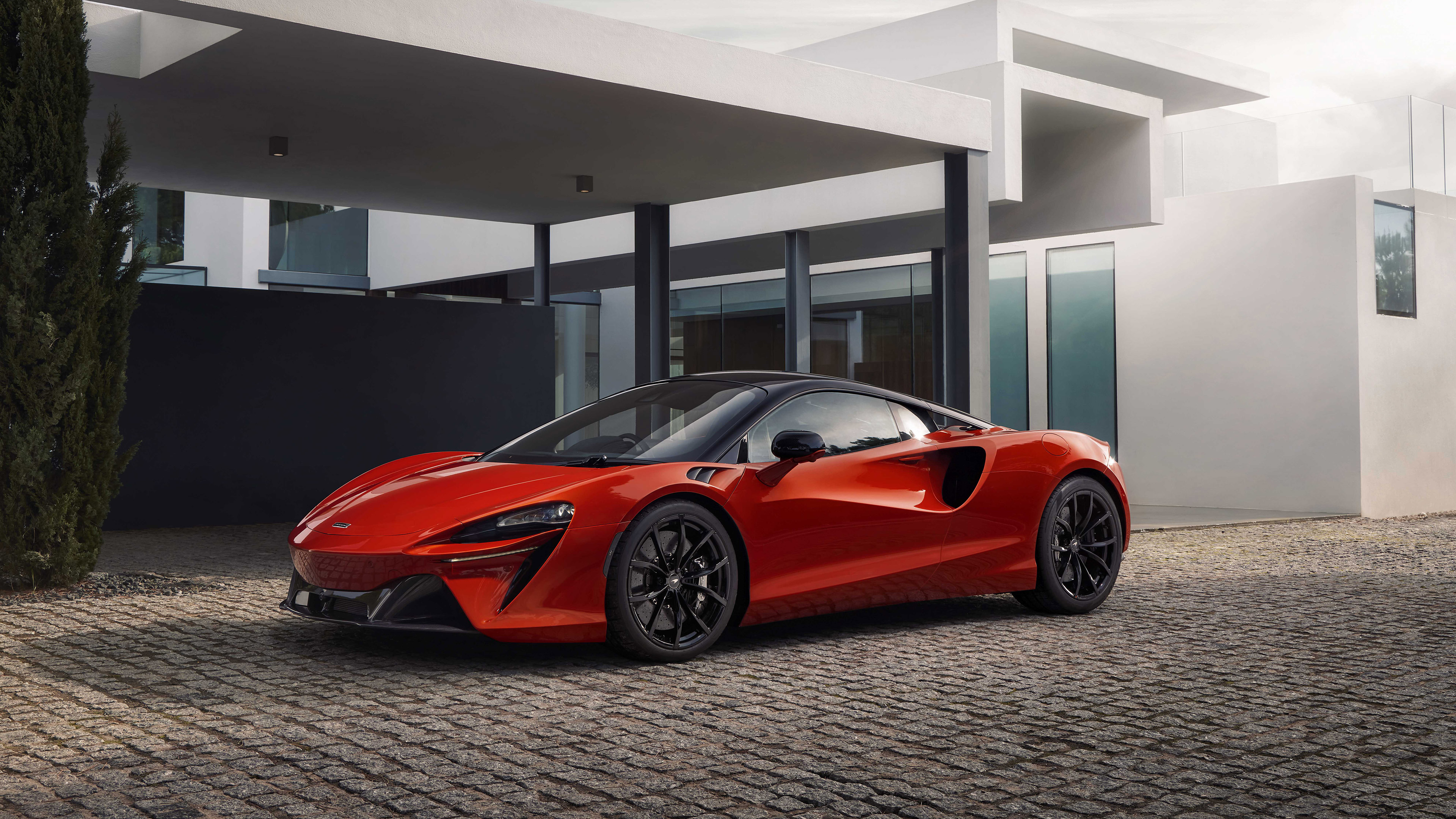Red McLaren Artura supercar parked in front of a modern house HD Wallpaper