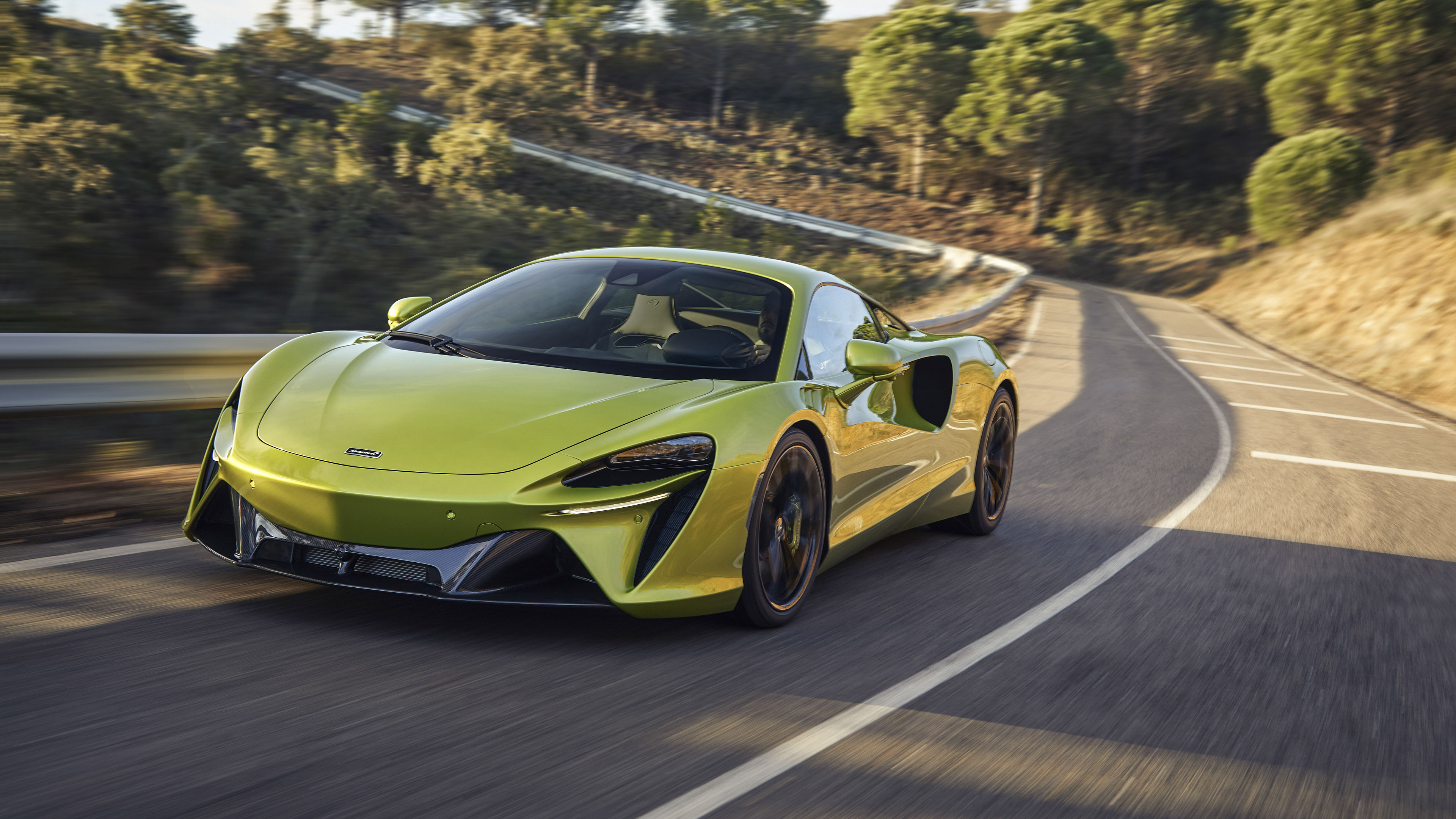 Green McLaren Artura driving on a winding road HD Wallpaper