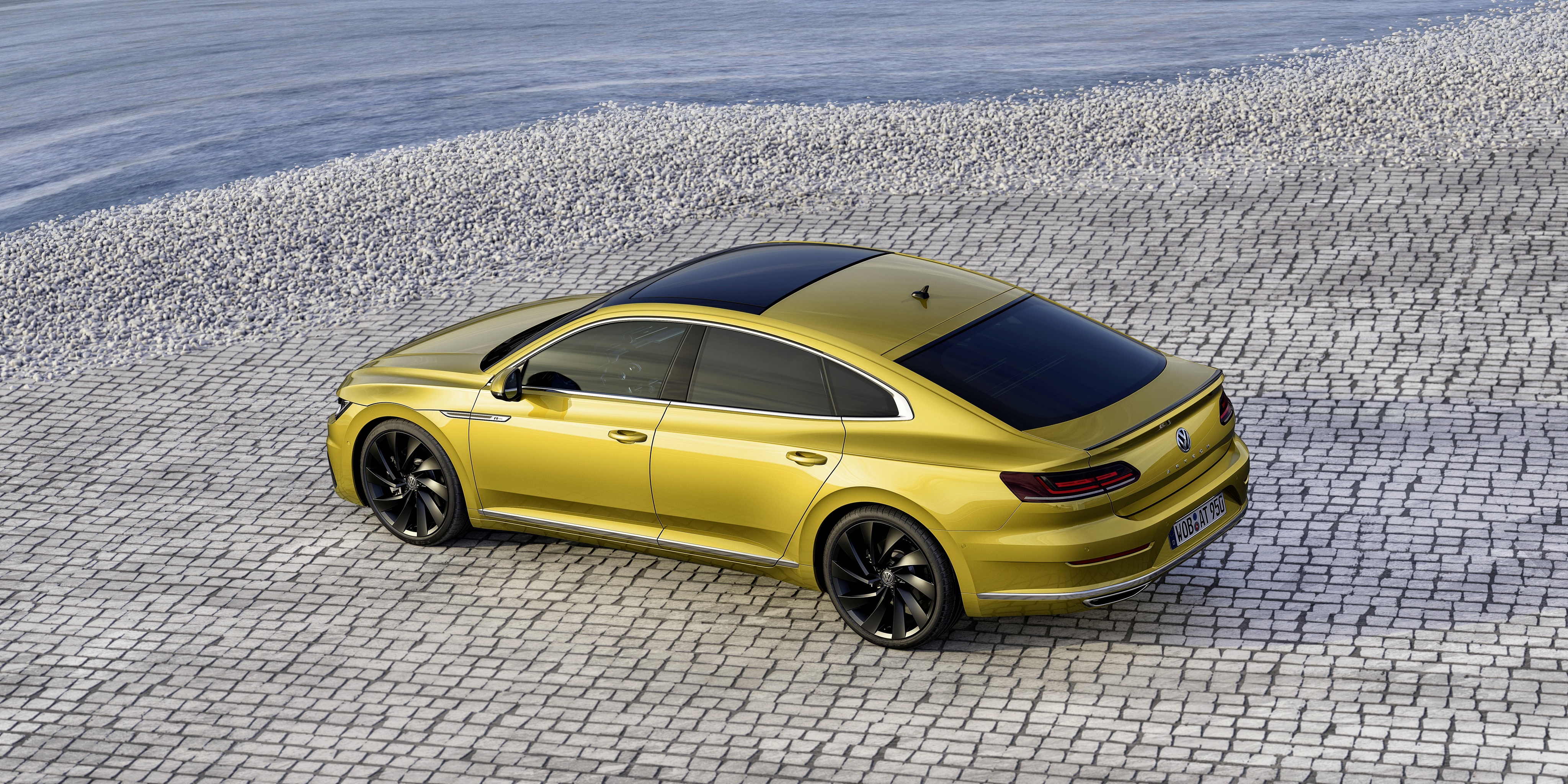 Yellow Volkswagen Arteon R-Line parked on cobblestone HD Wallpaper