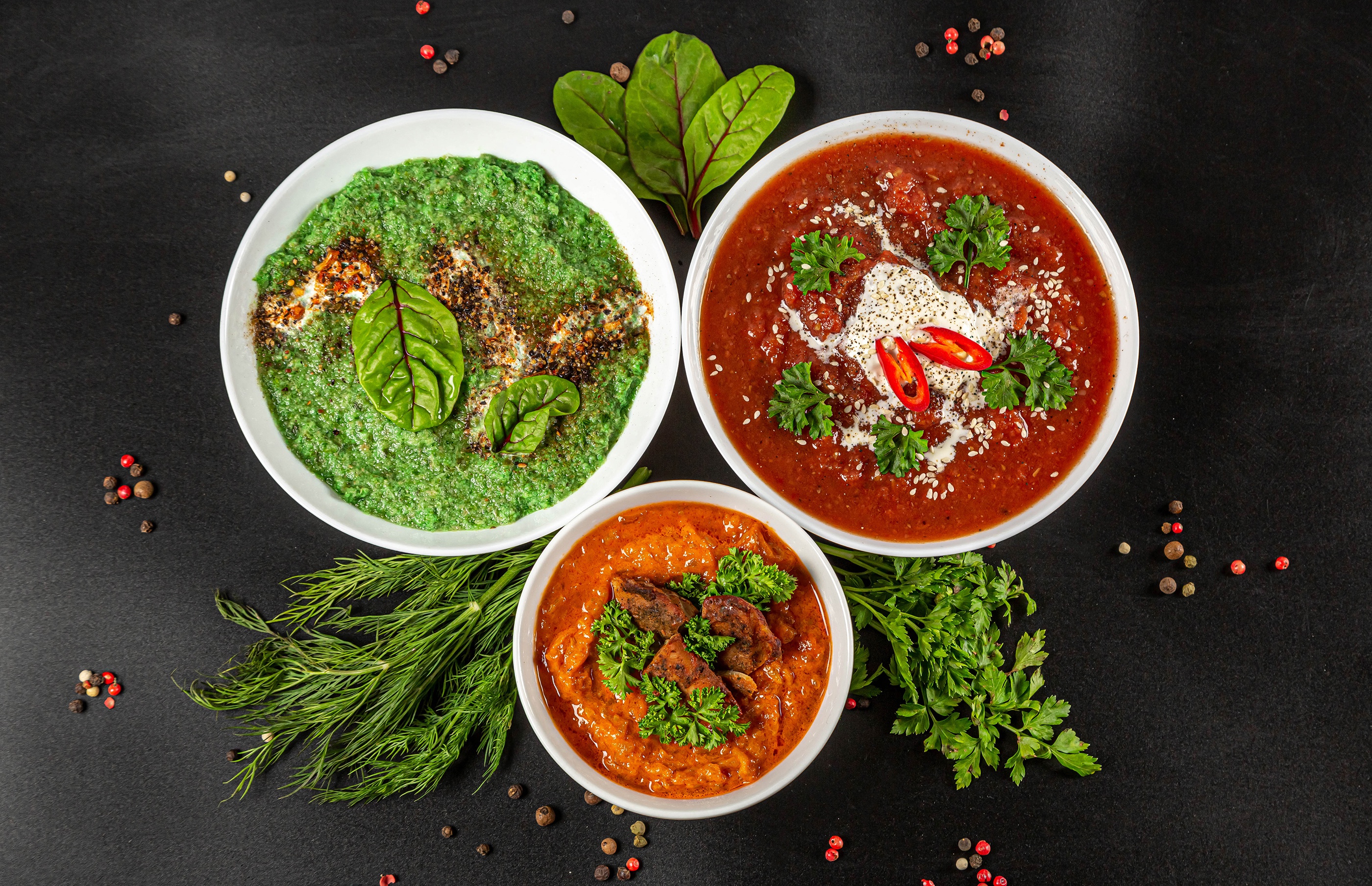 Three bowls of soup with garnishes and peppercorns HD Wallpaper