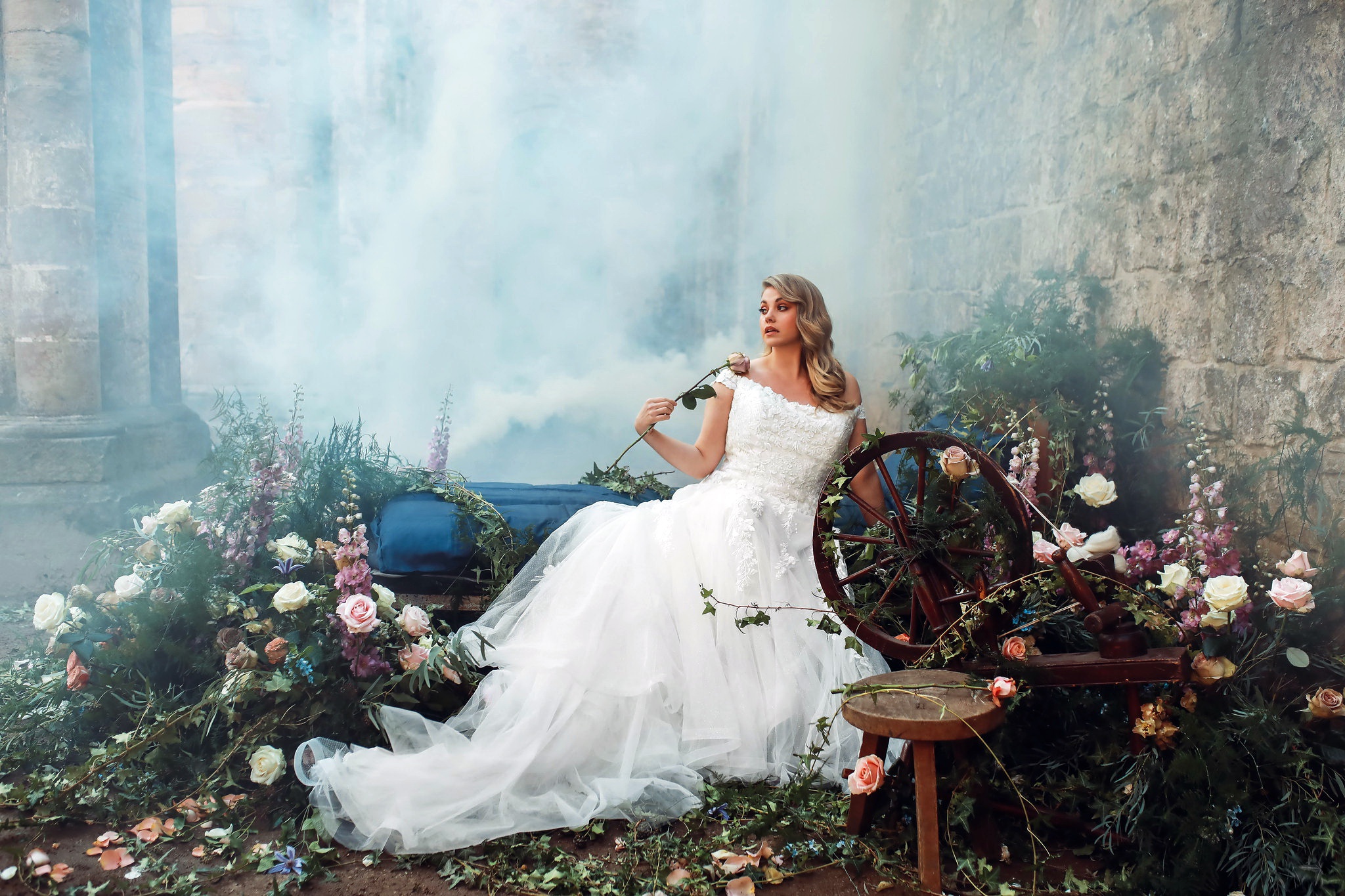 Bride in white dress holding a rose near a spinning wheel HD Wallpaper