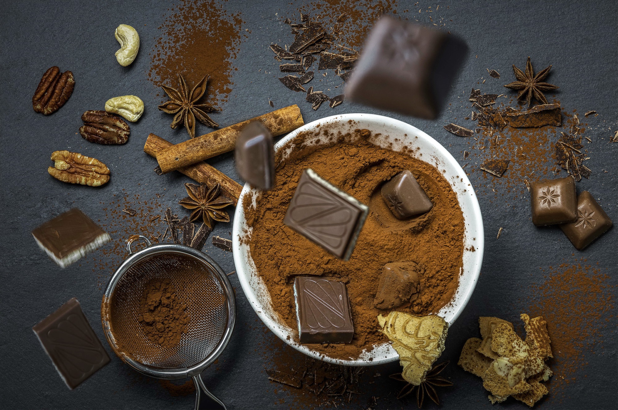 Chocolate, nuts, cinnamon, and star anise on a dark surface HD Wallpaper