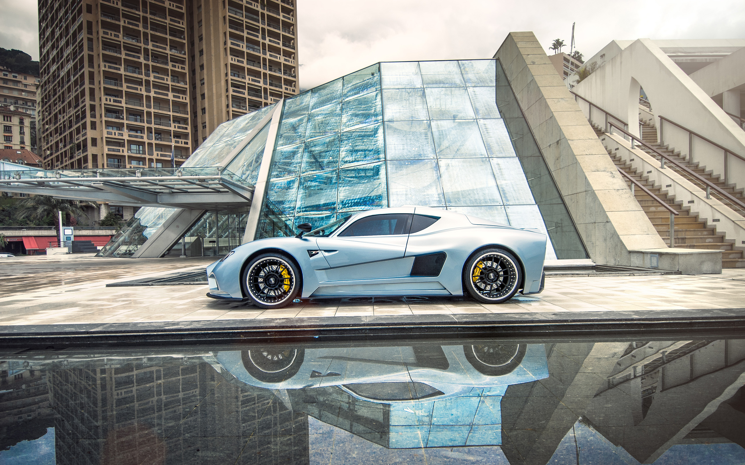 Mazzanti Evantra silver sport car in front of modern architecture HD Wallpaper