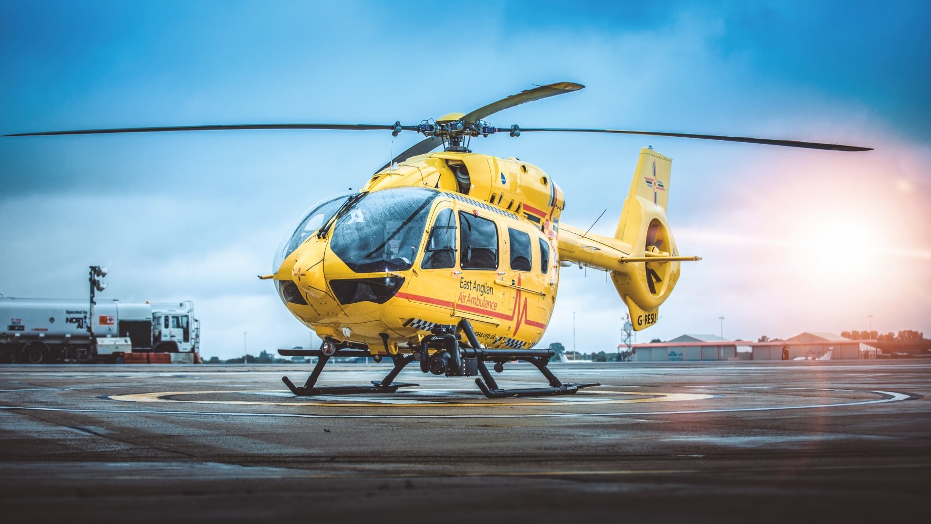 East Anglian Air Ambulance helicopter on tarmac HD Wallpaper