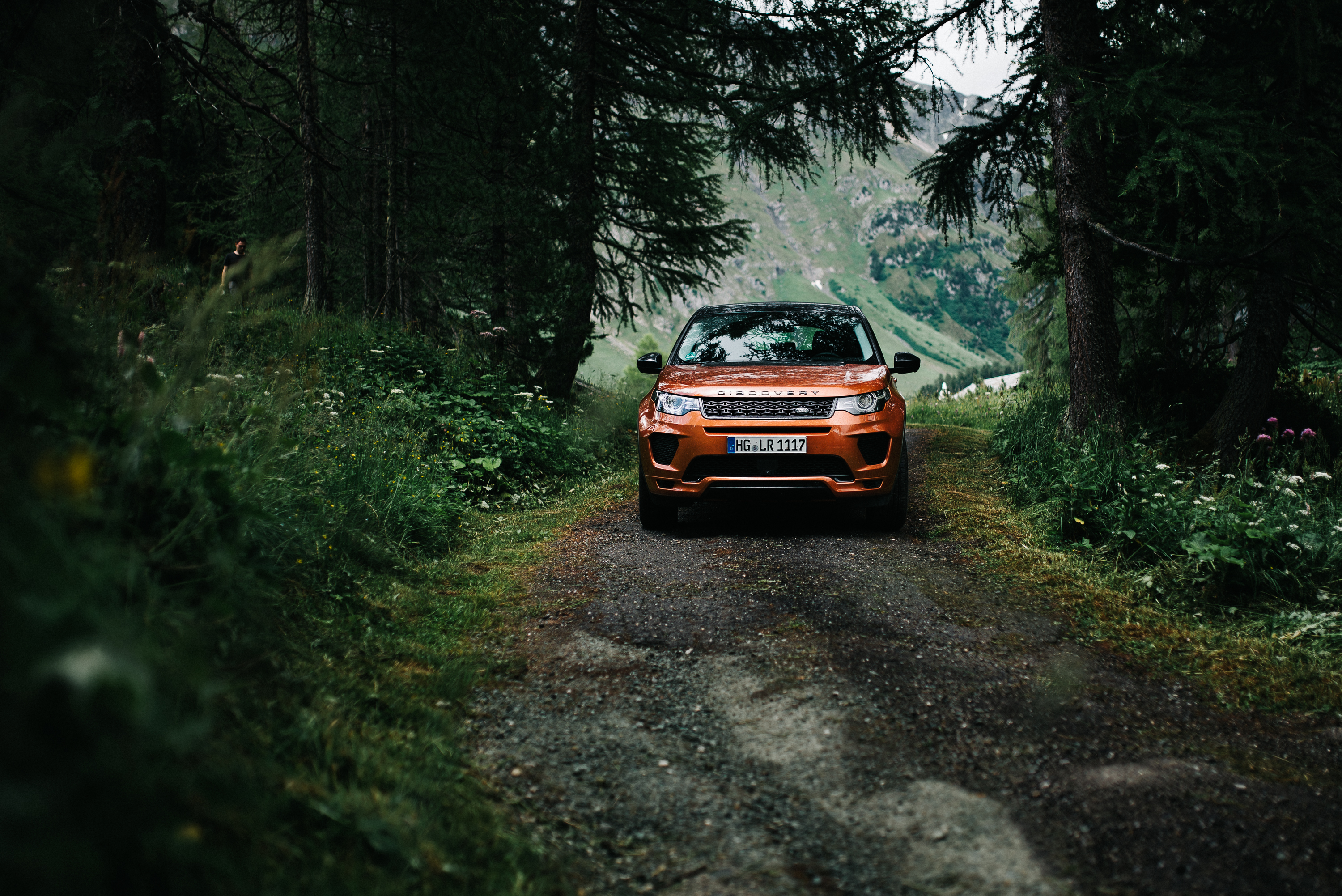 Orange Land Rover Discovery on a forest road HD Wallpaper
