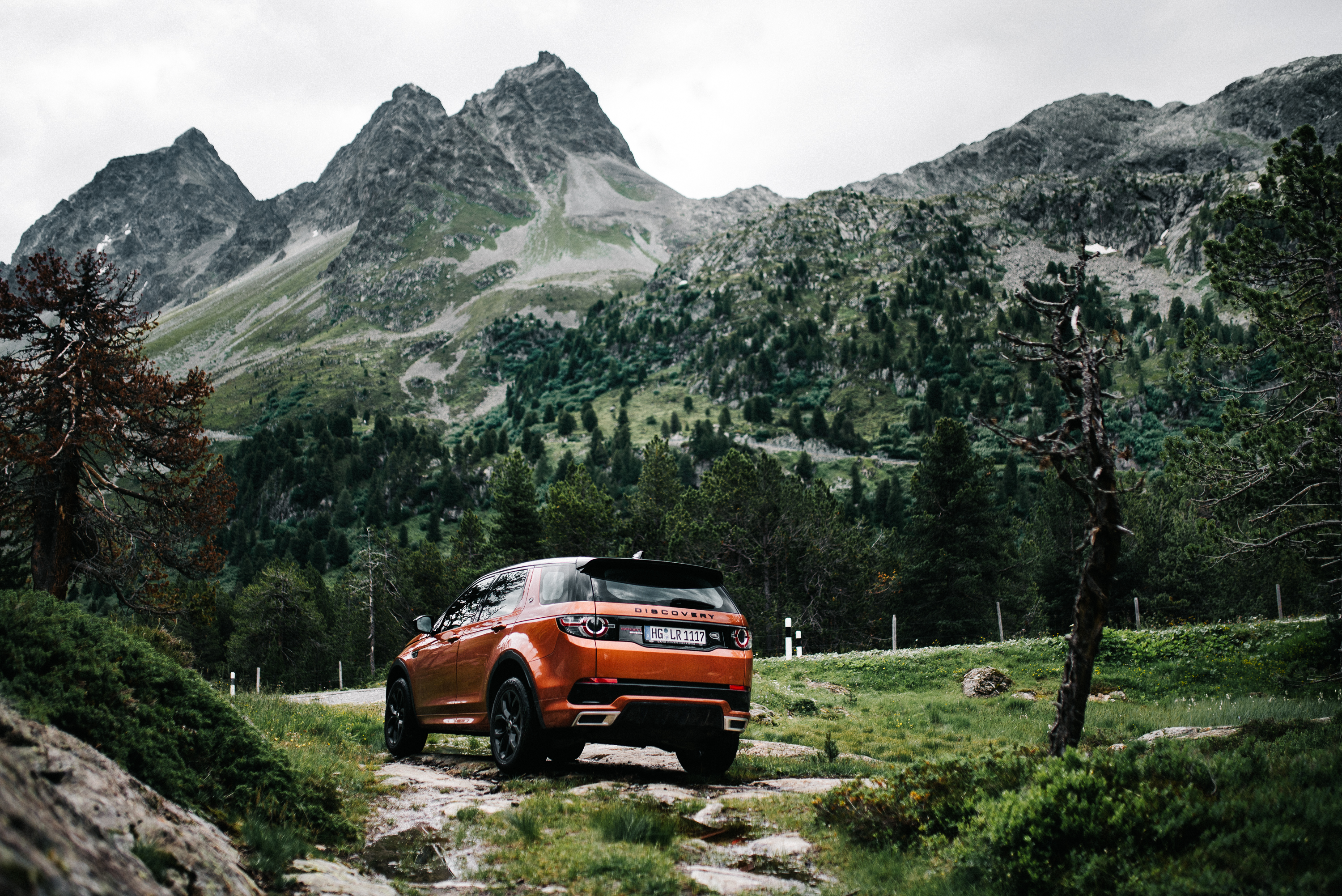 Orange Land Rover Discovery Sport on a mountain road HD Wallpaper