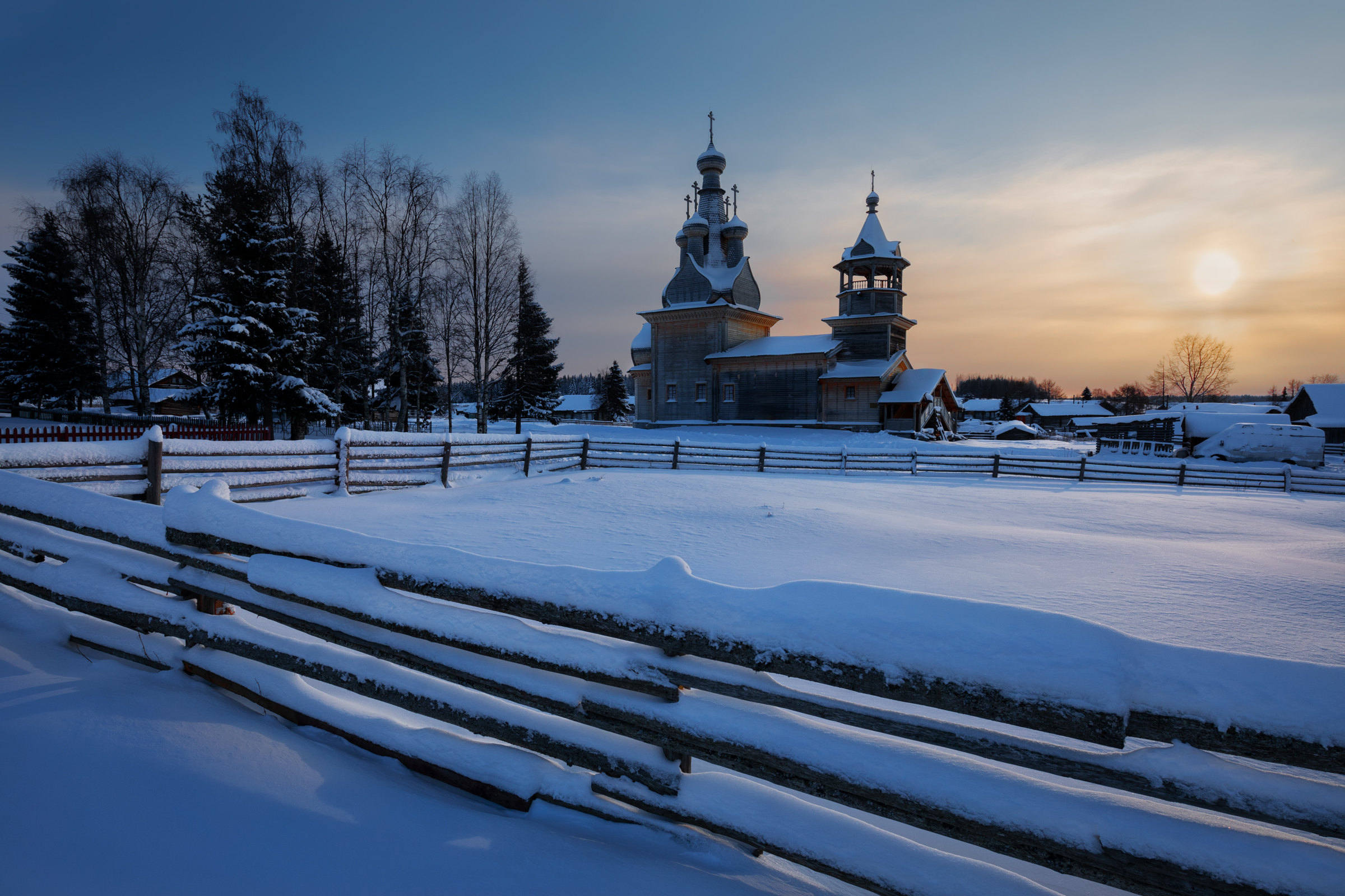 Wooden church in a snowy village at sunset HD Wallpaper