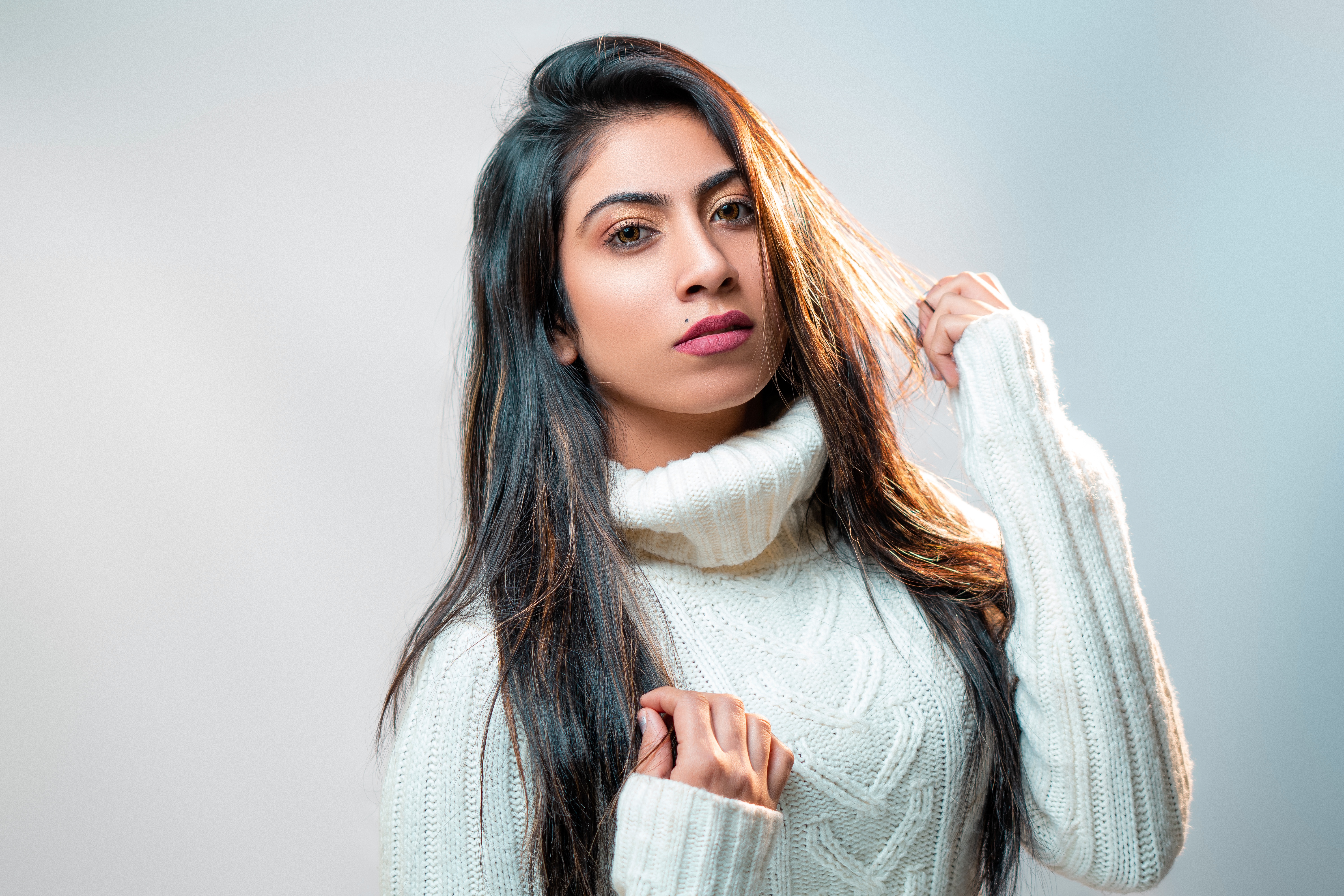 Woman with long brunette hair wearing a white turtleneck sweater HD Wallpaper