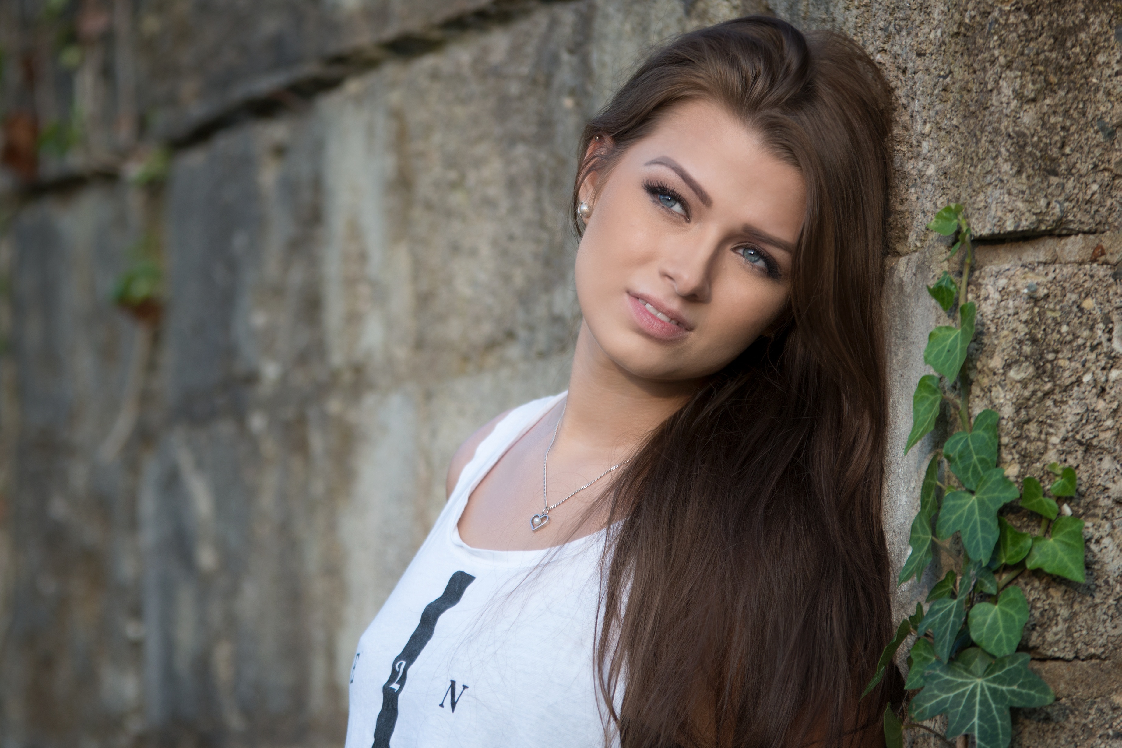 Brunette Woman with Blue Eyes Near Stone Wall HD Wallpaper