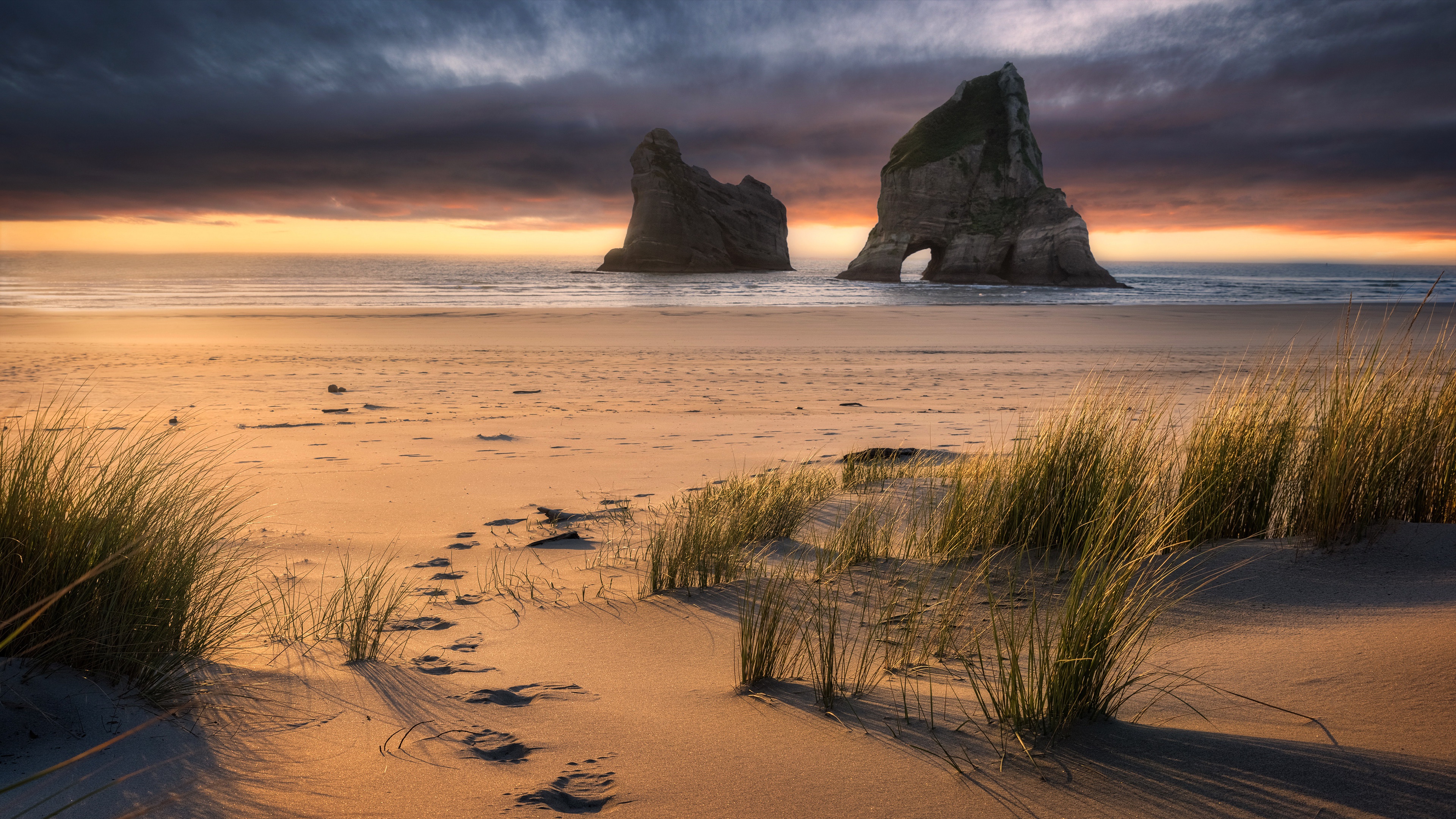 Beach with rock formations at sunset in New Zealand HD Wallpaper