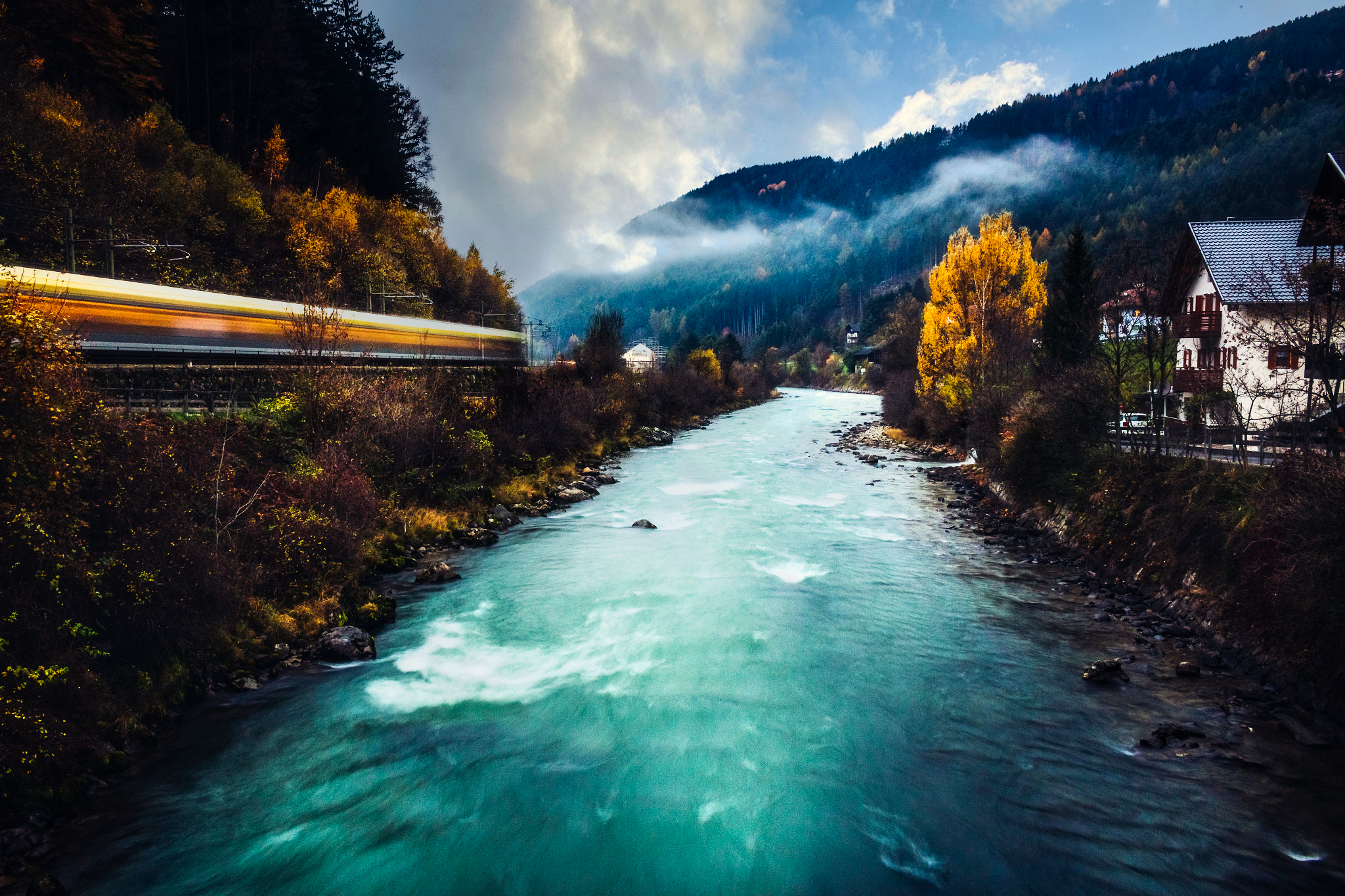 Train passing by a river in the Alps HD Wallpaper