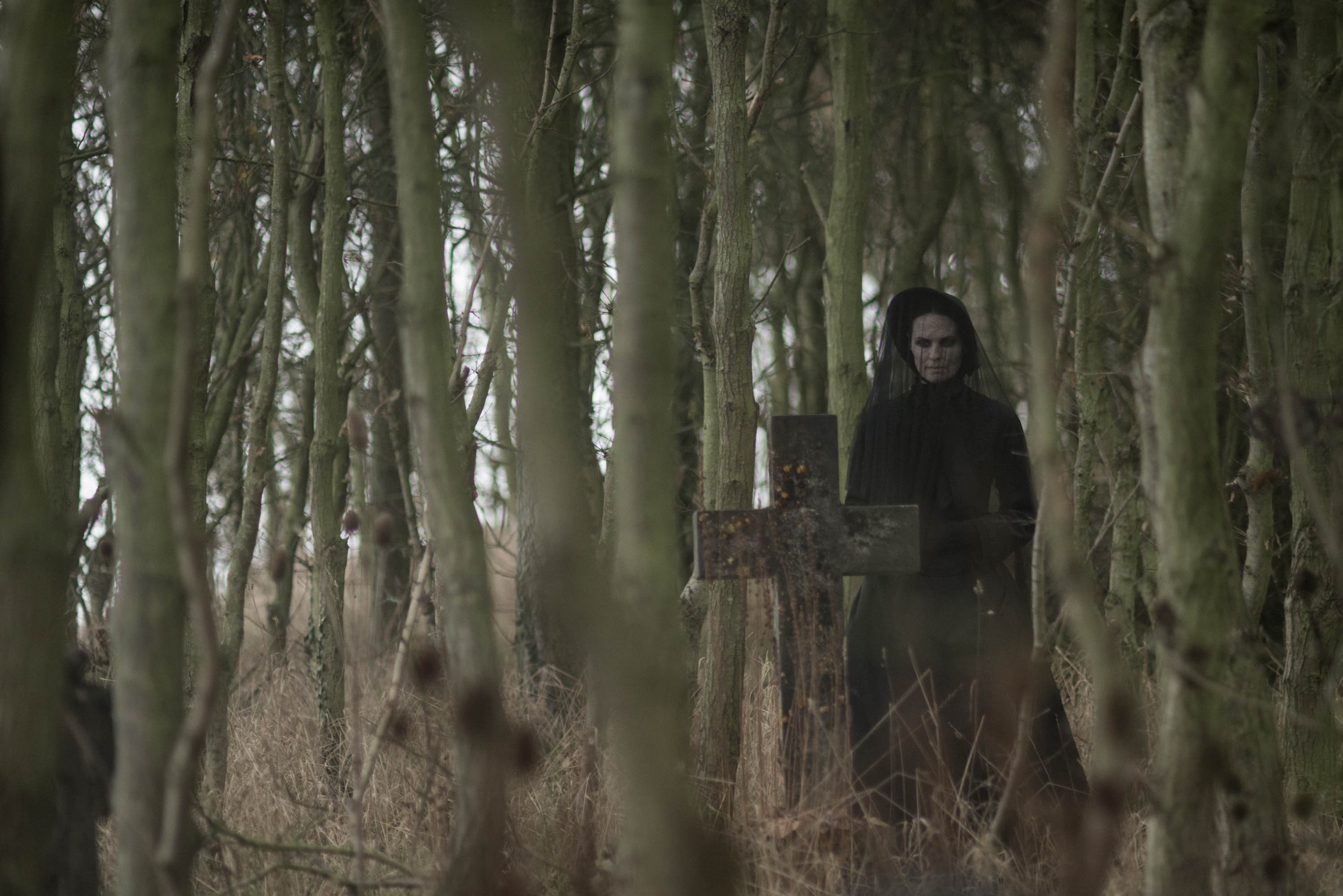 Woman in black veil at a grave in a forest HD Wallpaper