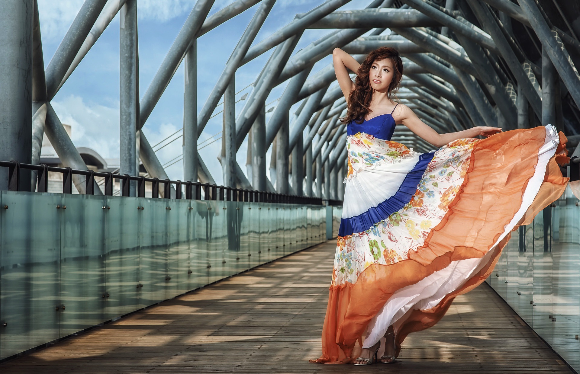 Woman in a flowing dress on a modern bridge HD Wallpaper