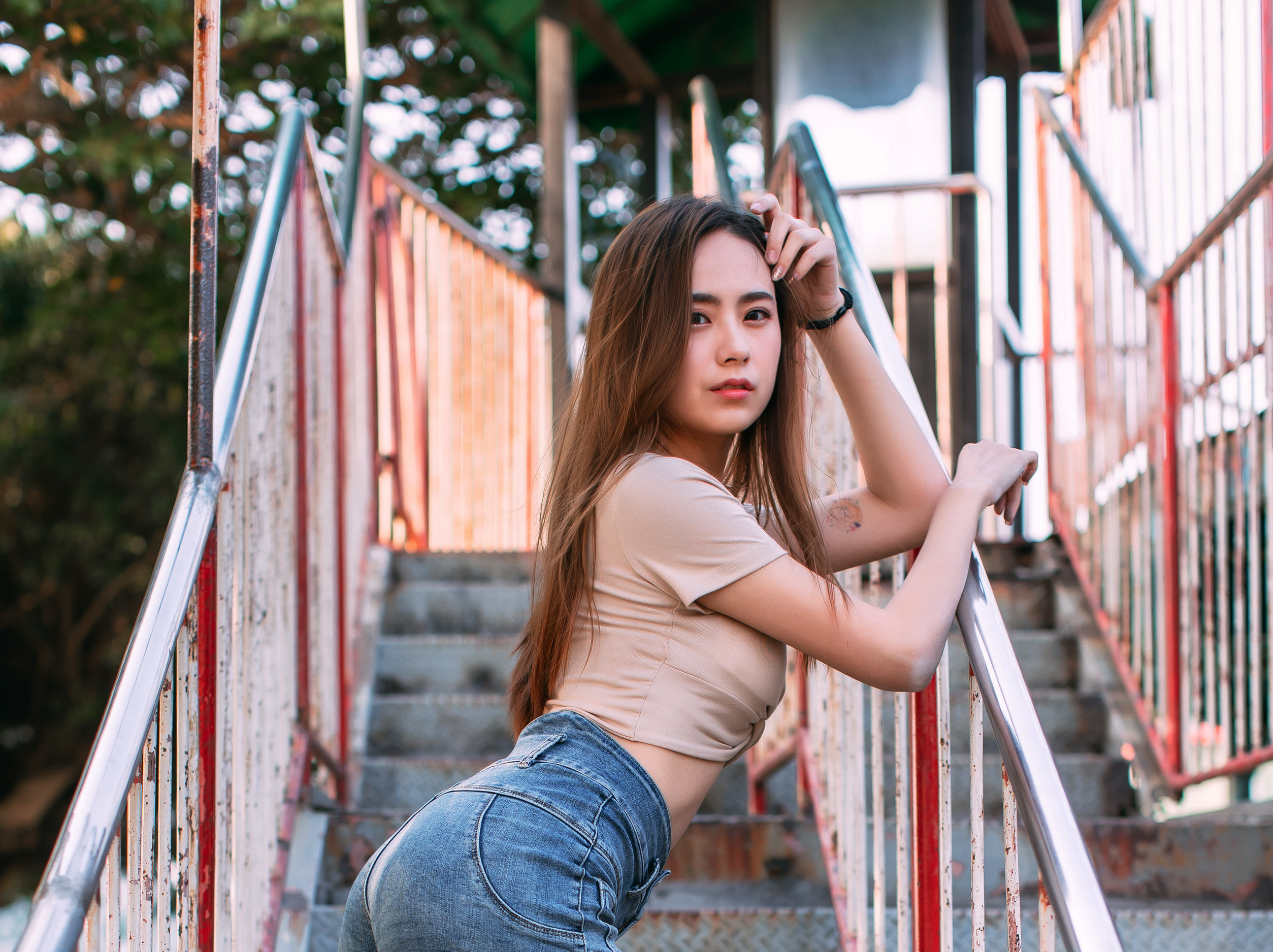 Asian woman in jeans and crop top on stairs HD Wallpaper