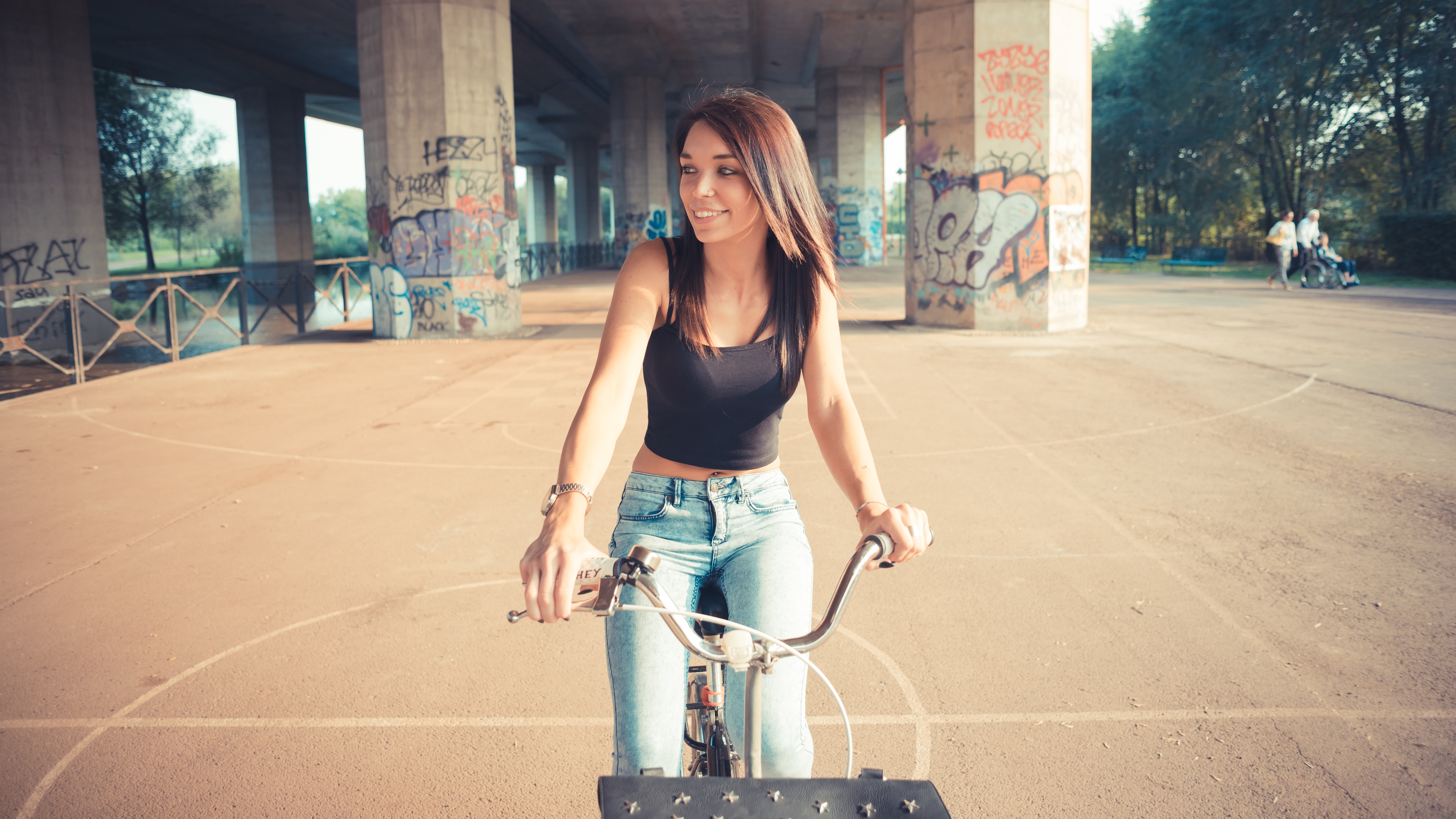 Woman on a bicycle under a bridge HD Wallpaper