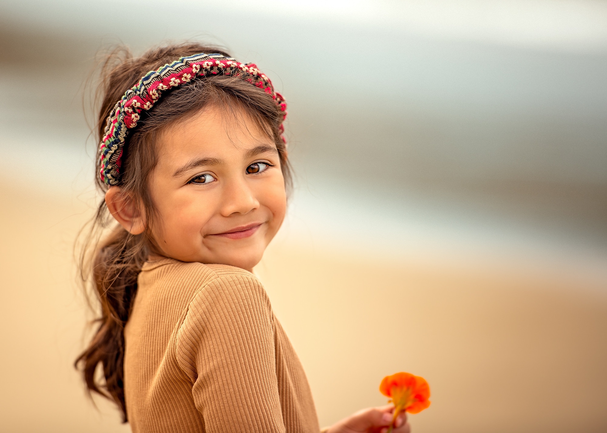 Young girl with headband holding a flower HD Wallpaper