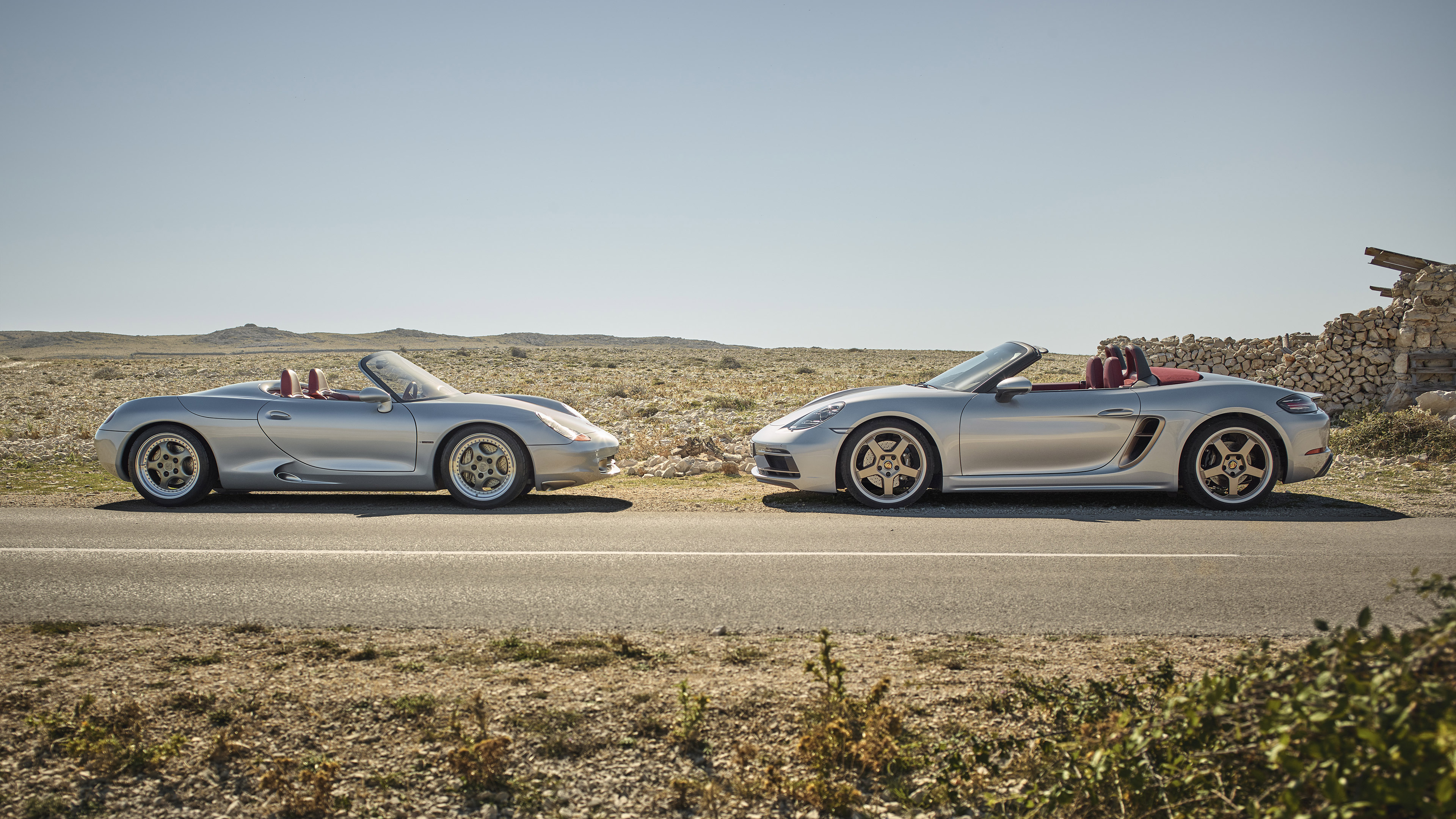 Two silver Porsche Boxster cars on a road HD Wallpaper
