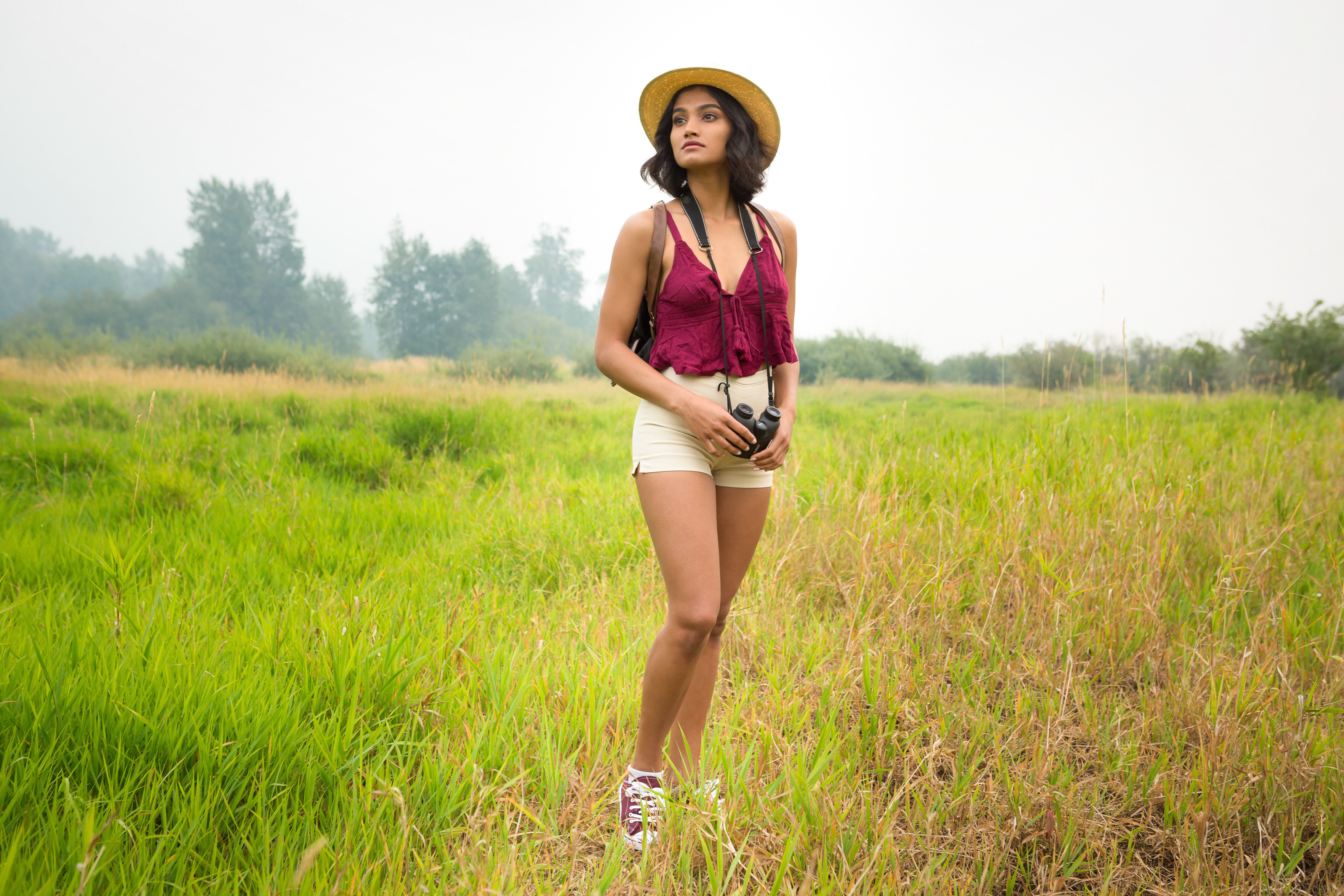 Woman with binoculars in a field HD Wallpaper