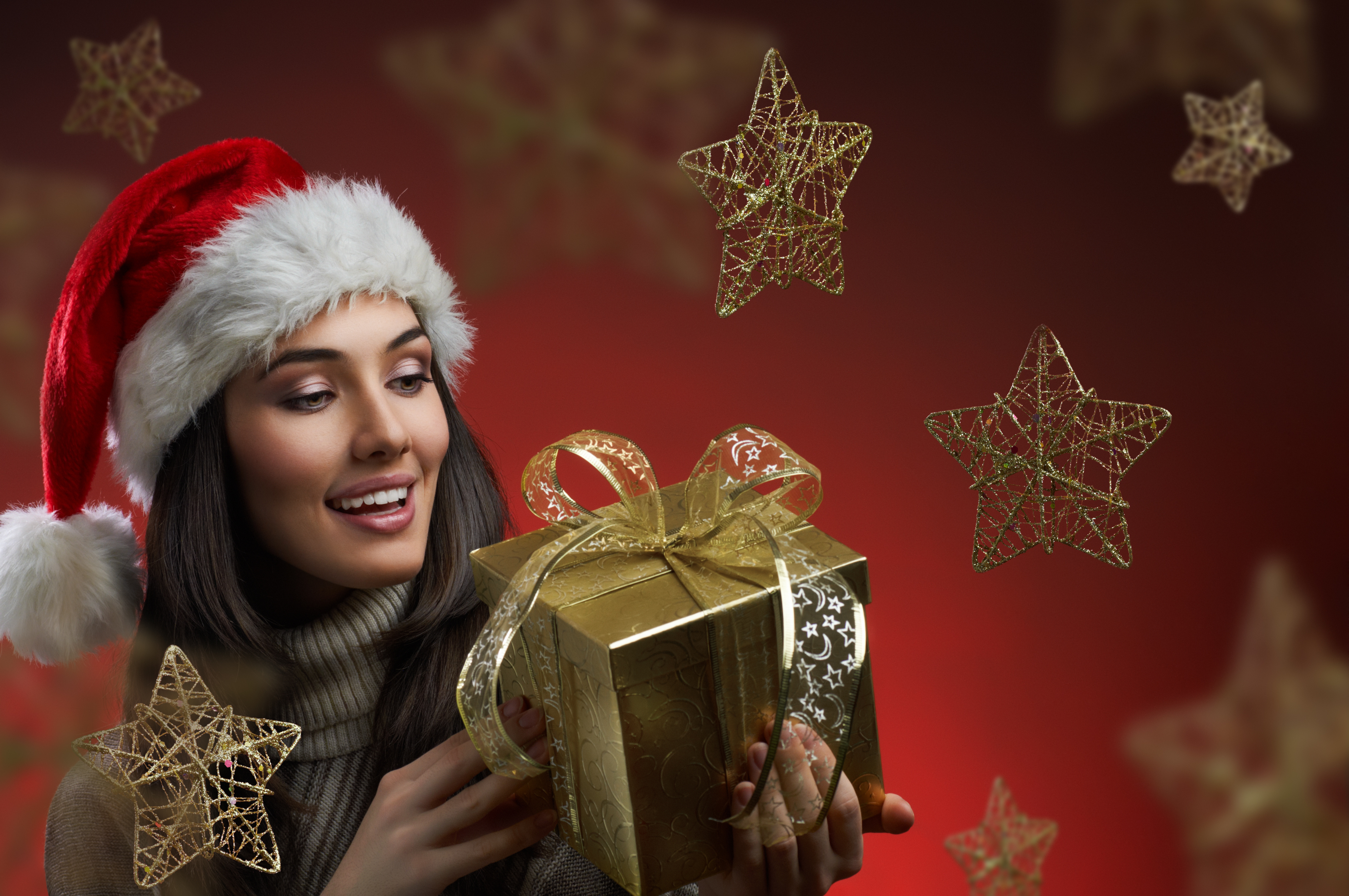 Woman in Santa Hat Holding a Gift HD Wallpaper