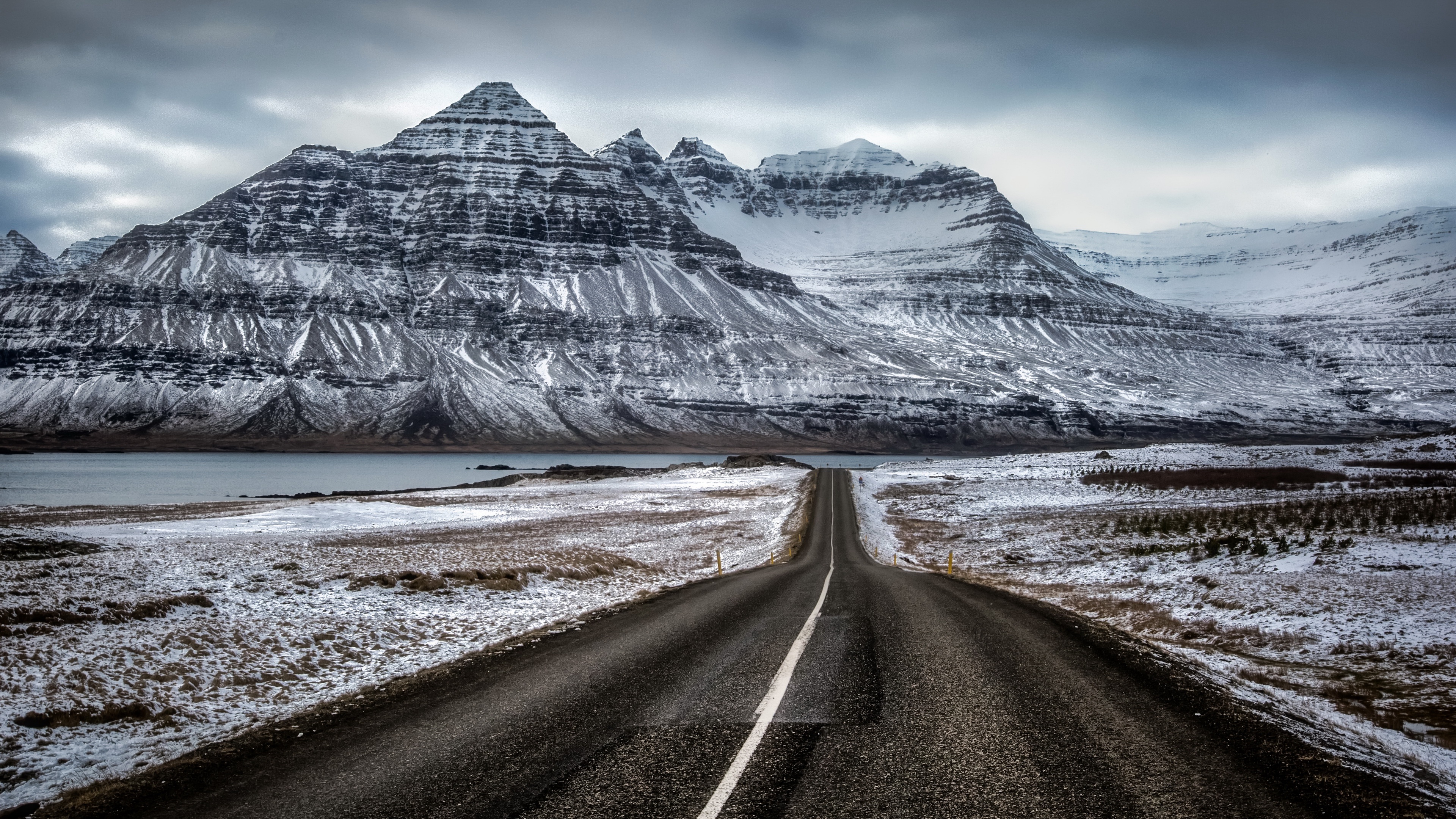Road leading to snow-covered mountains in Iceland 4K HD Wallpaper