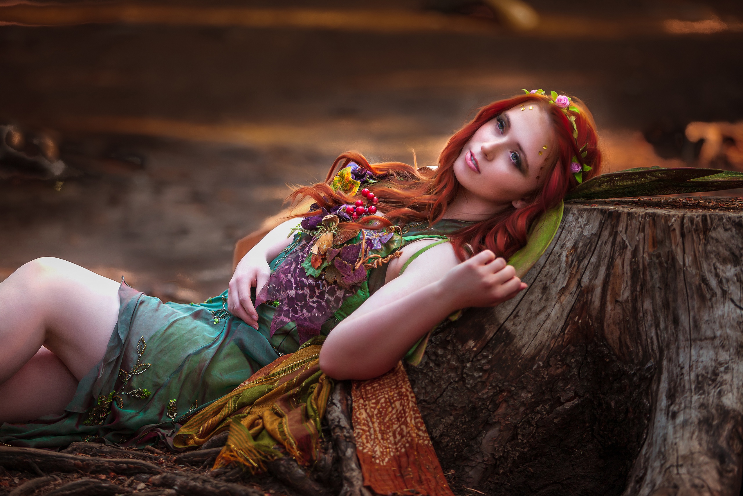 Redhead woman in a green dress lying on a tree stump HD Wallpaper