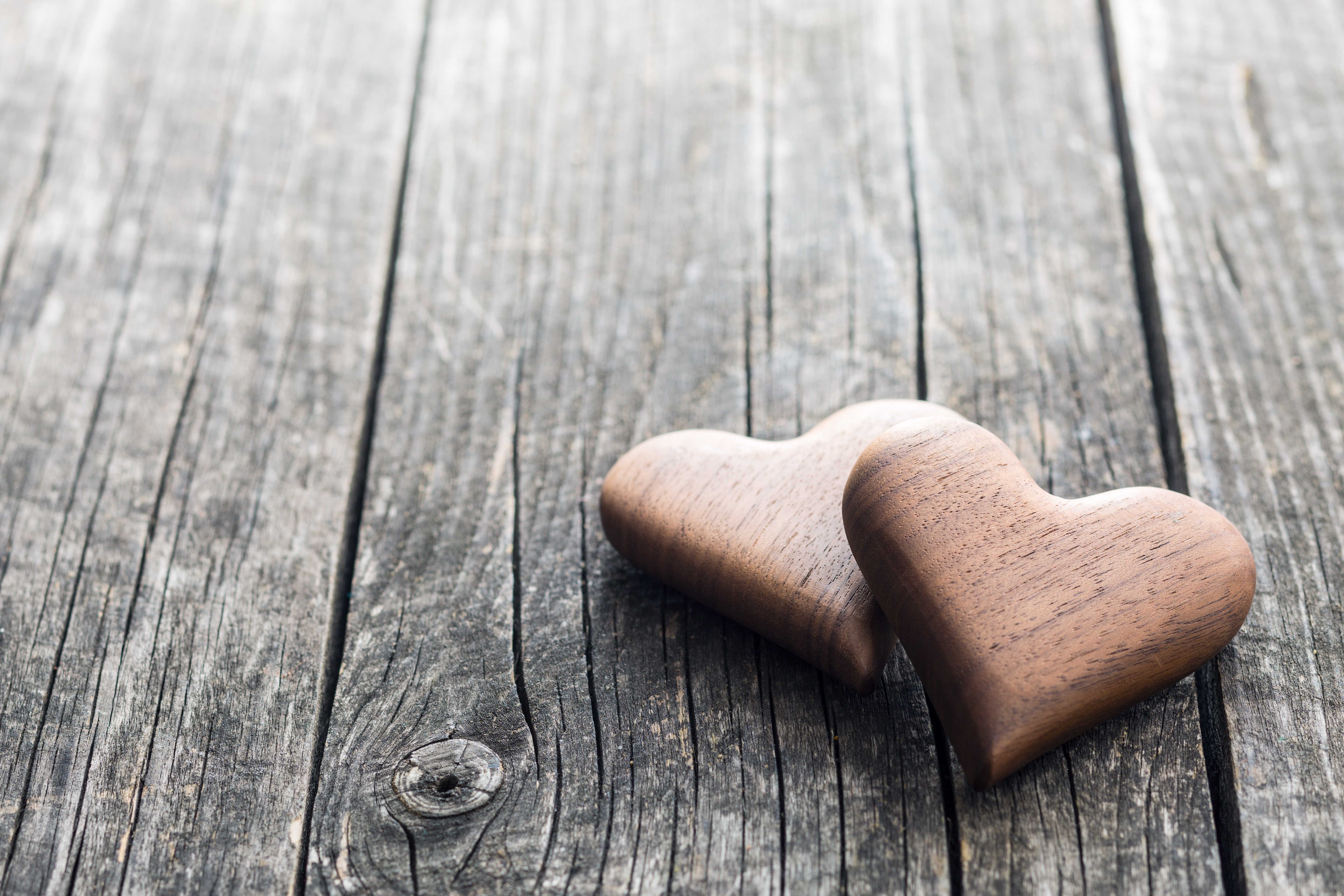 Two wooden hearts on a rustic wooden surface HD Wallpaper