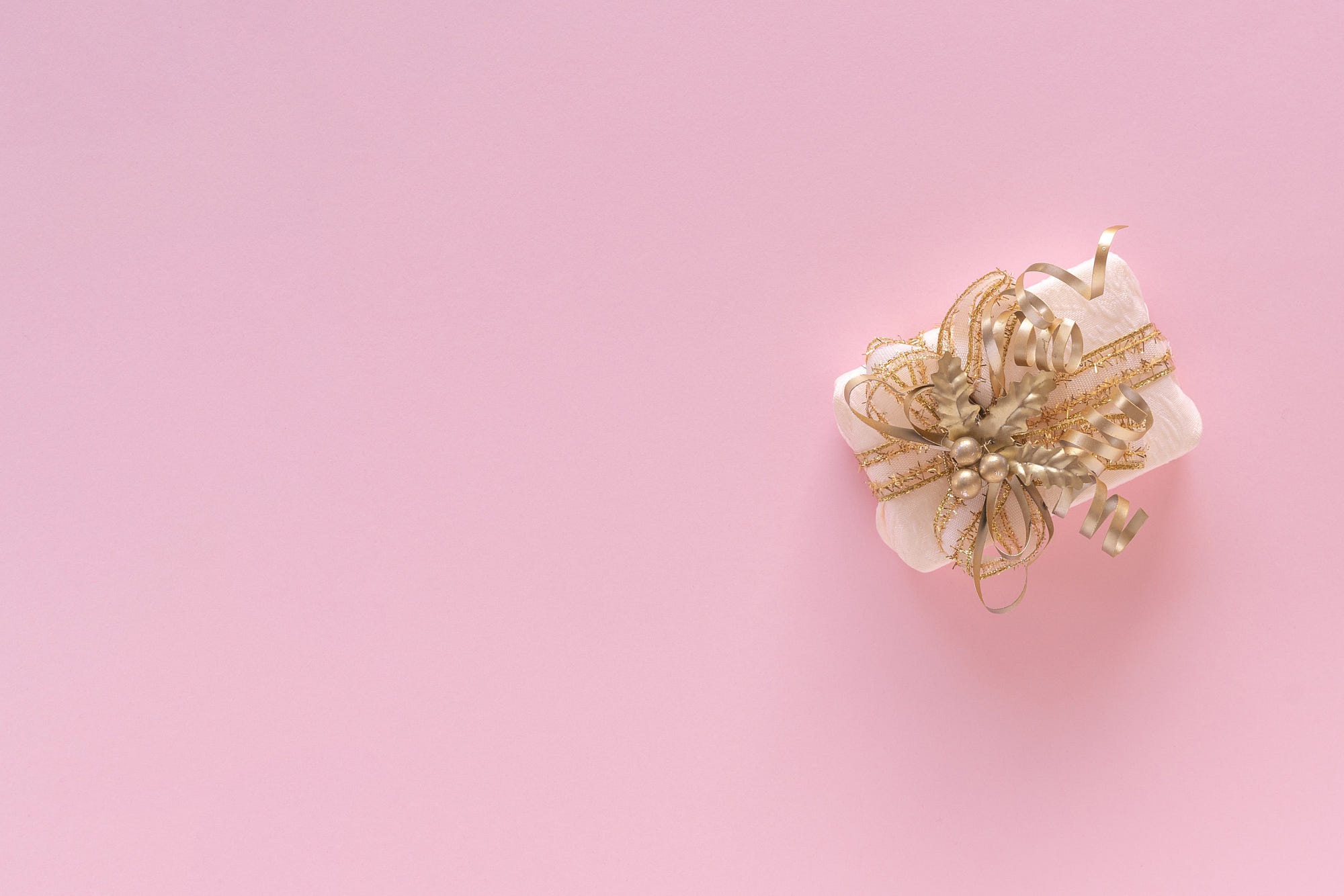 Gift box with golden ribbon on pink background HD Wallpaper